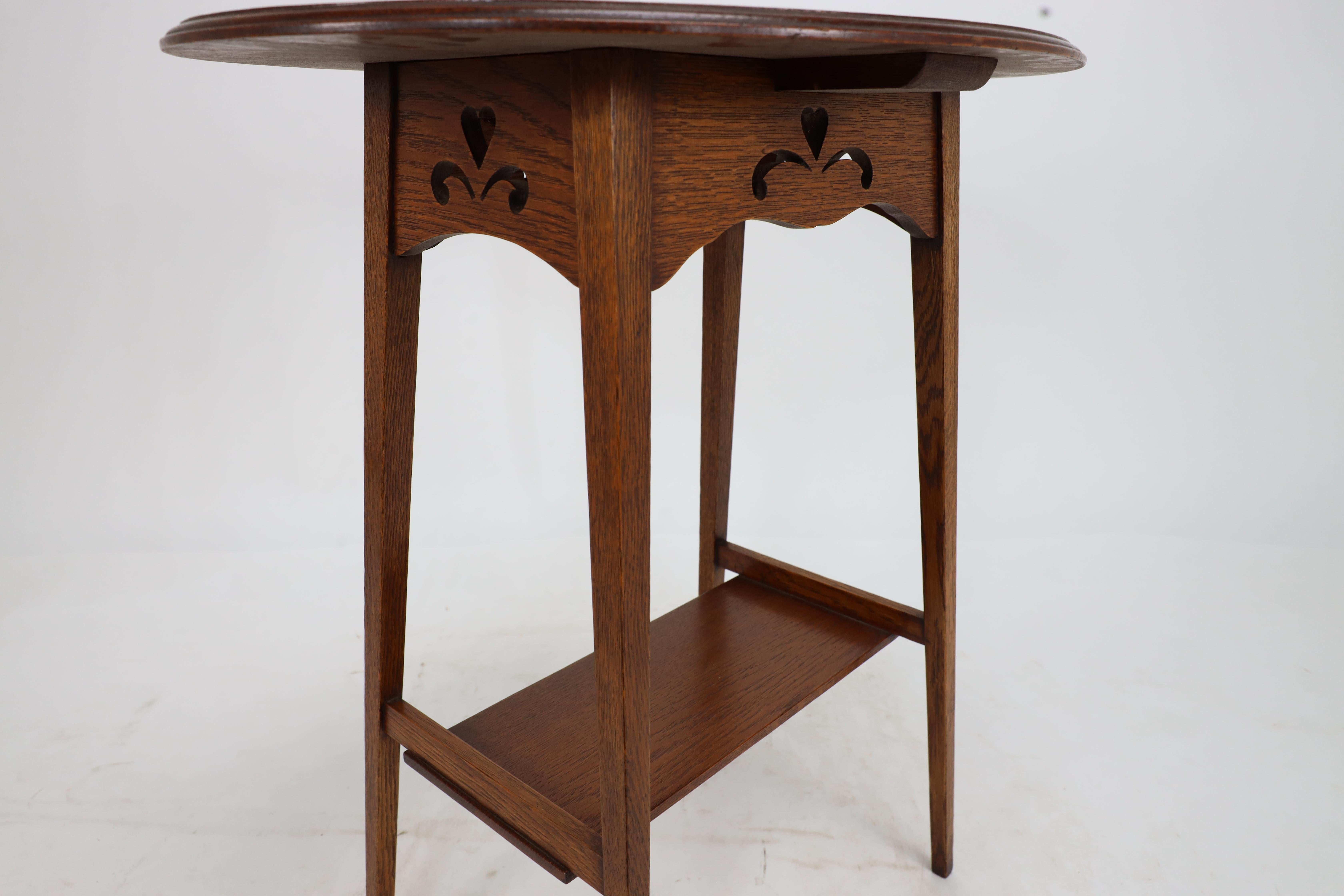 Liberty & Co. An Arts & Crafts oak oval top side table with heart cut-outs 11
