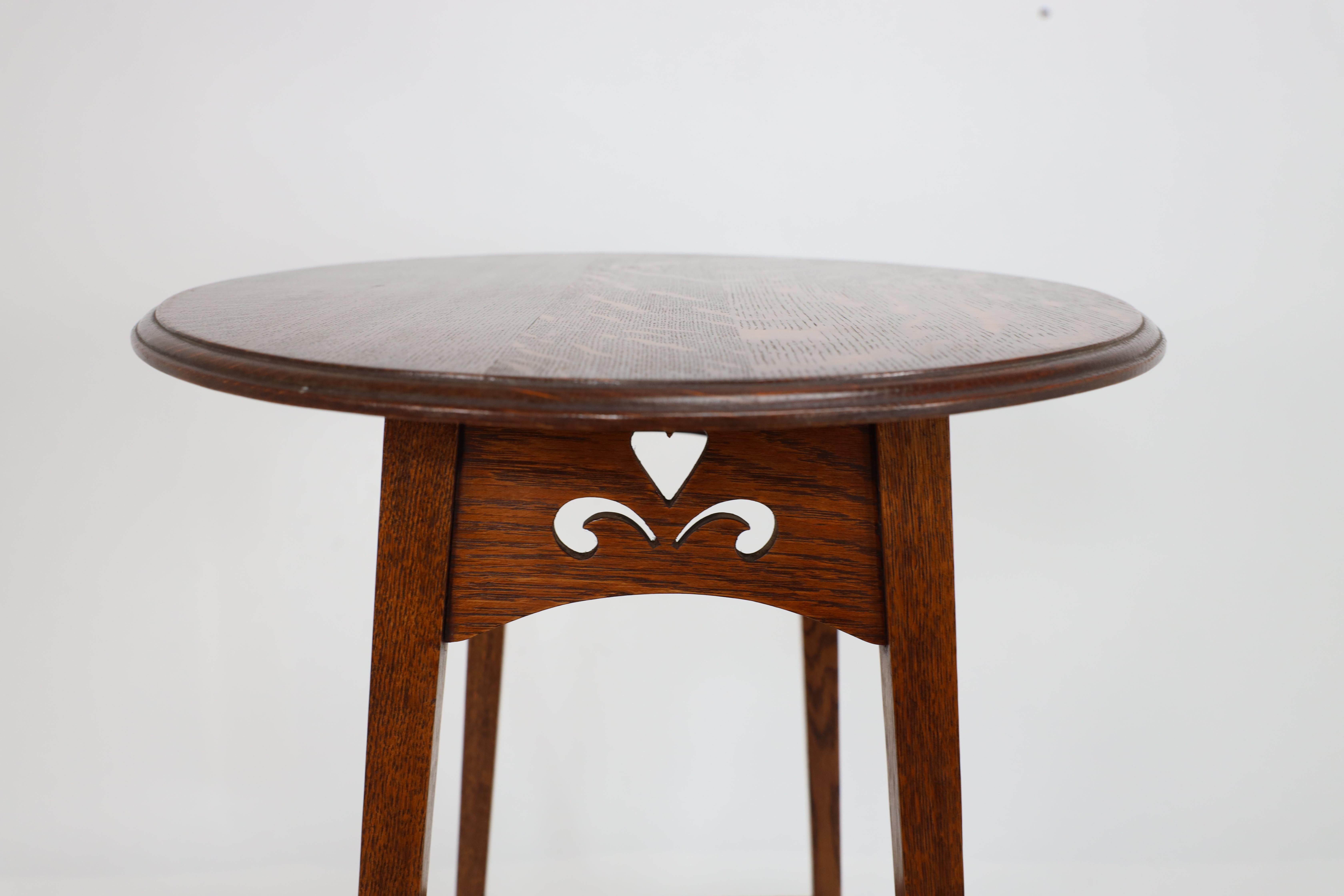Liberty & Co. An Arts & Crafts oak oval top side table with heart cut-outs 13