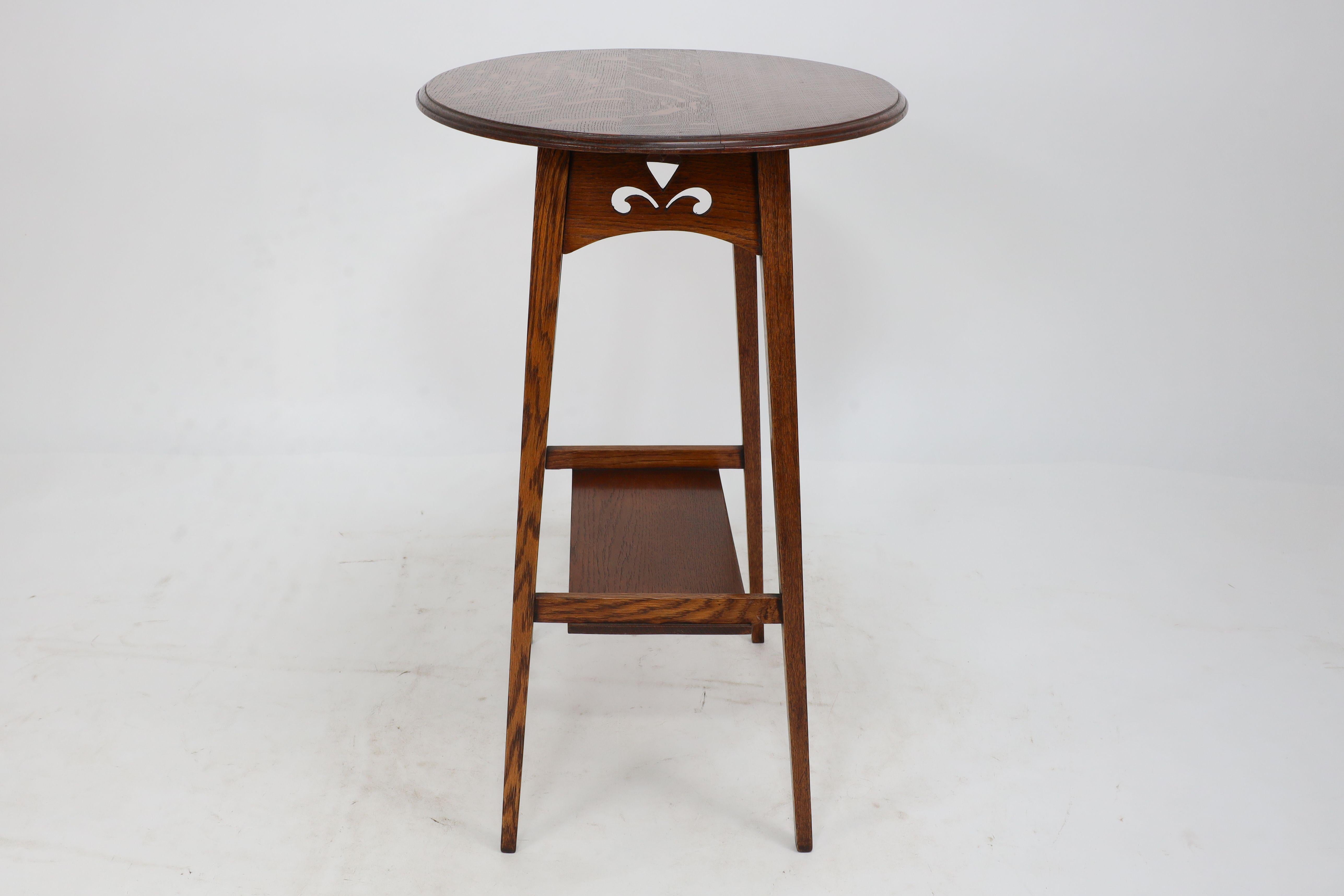 Arts and Crafts Liberty & Co. An Arts & Crafts oak oval top side table with heart cut-outs