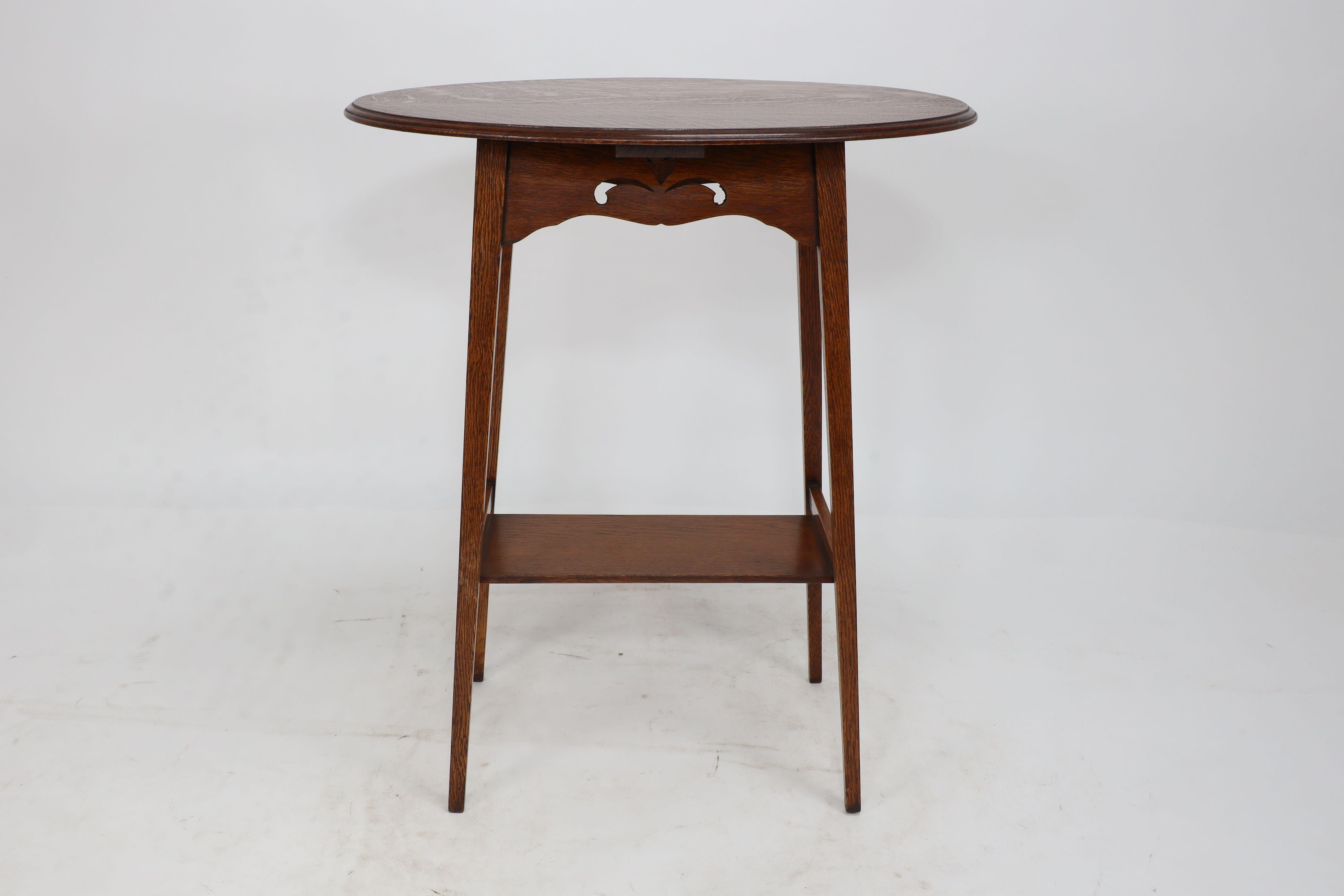 Liberty & Co. An Arts & Crafts oak oval top side table with heart cut-outs In Good Condition In London, GB