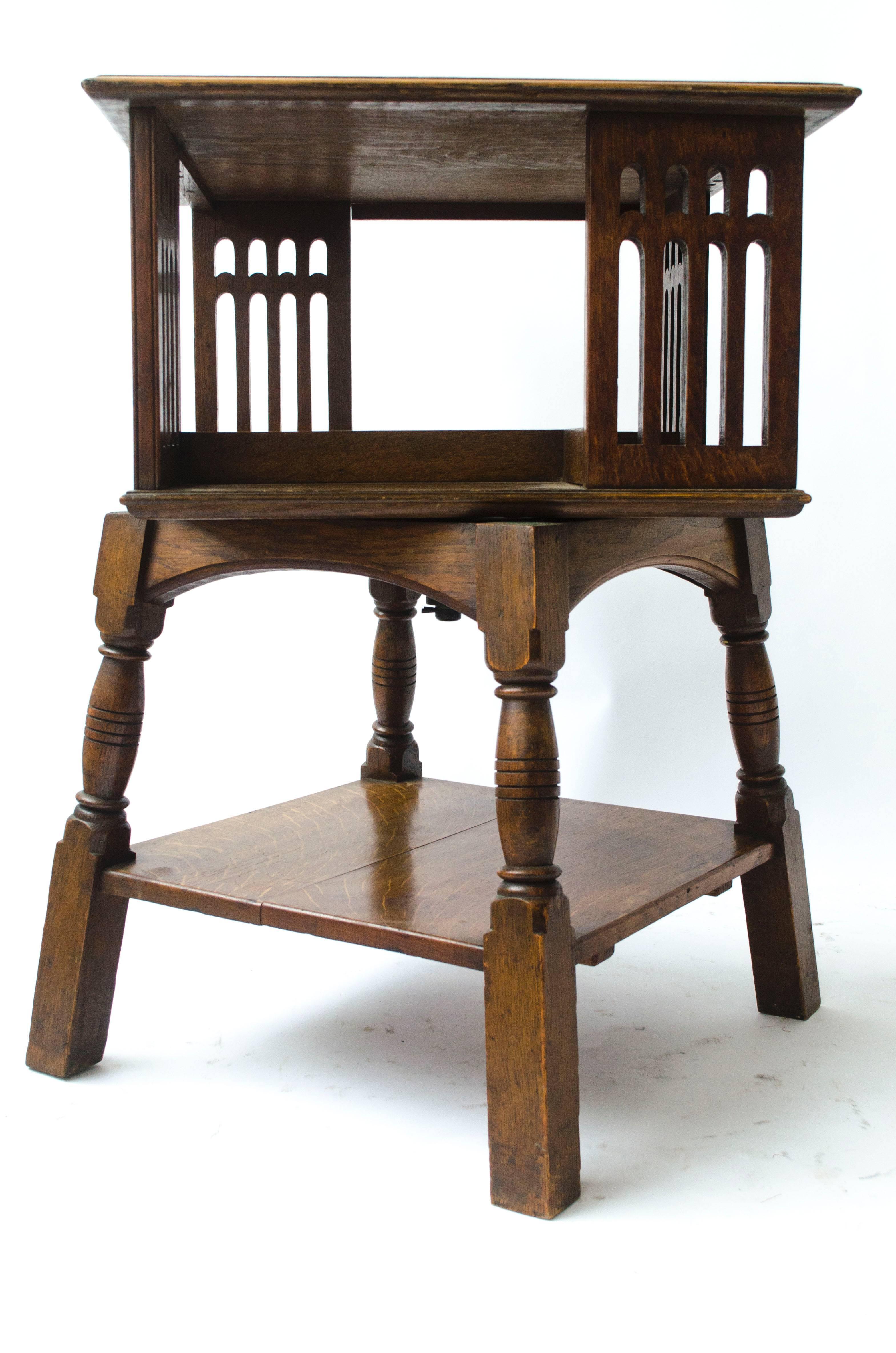 Arts and Crafts Liberty & Co an Arts & Crafts Oak Revolving Bookcase Table on Square Turned Legs