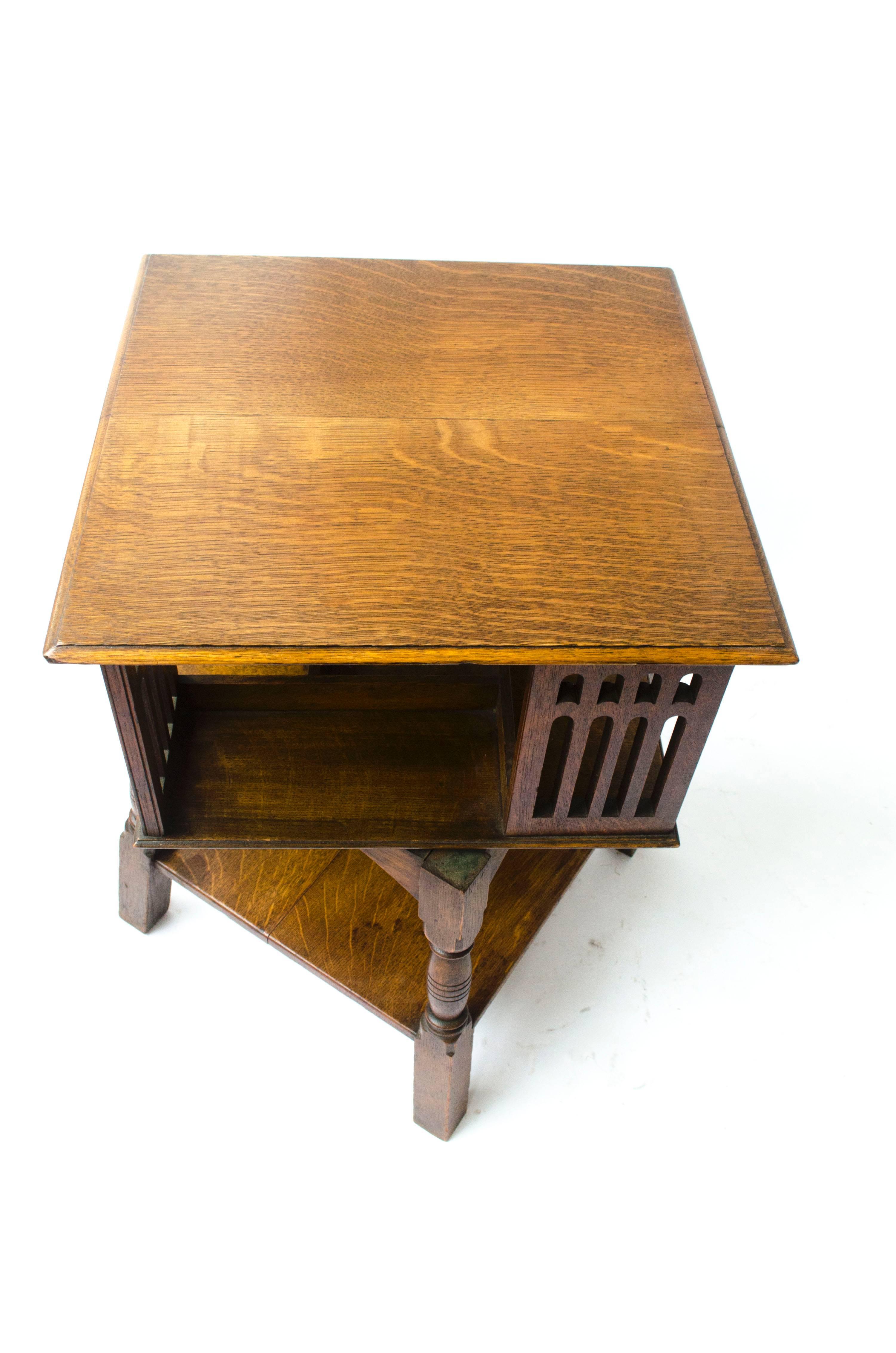 English Liberty & Co an Arts & Crafts Oak Revolving Bookcase Table on Square Turned Legs
