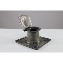 Liberty & Co. An Arts & Crafts Pewter Inkwell with Violet Enamel Decoration.