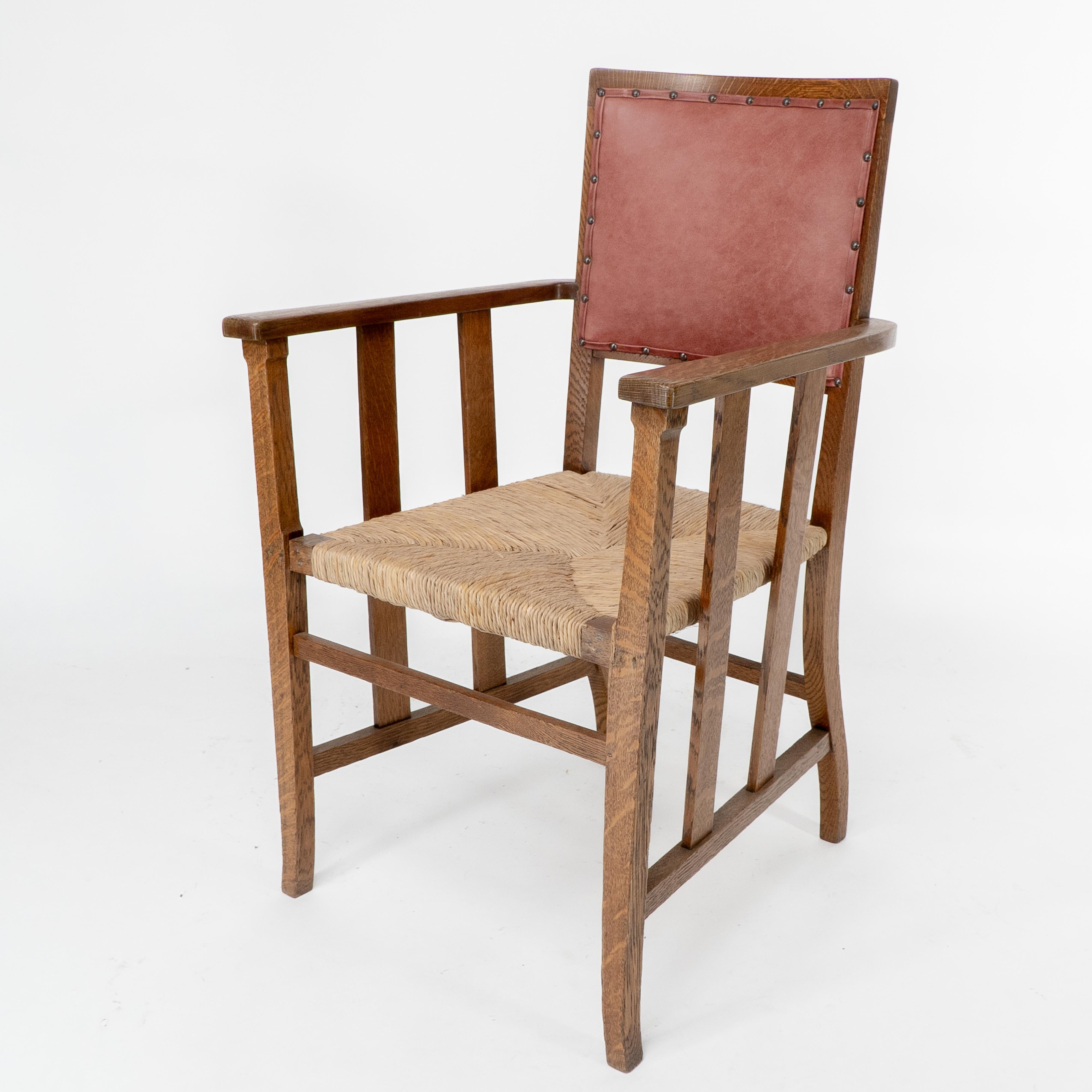 Arts and Crafts Liberty & Co. An Arts & Crafts rush seat armchair with a shaped back For Sale