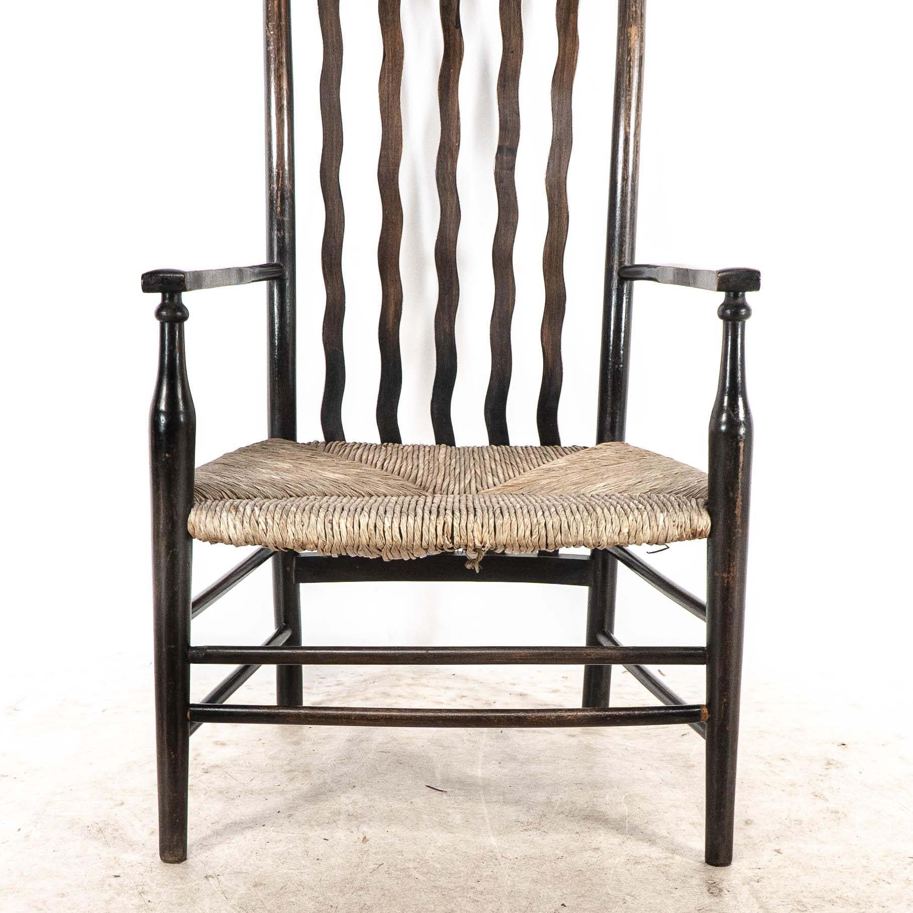 Liberty & Co. An Arts & Crafts rush seat armchair with wavy shaped back slats For Sale 3