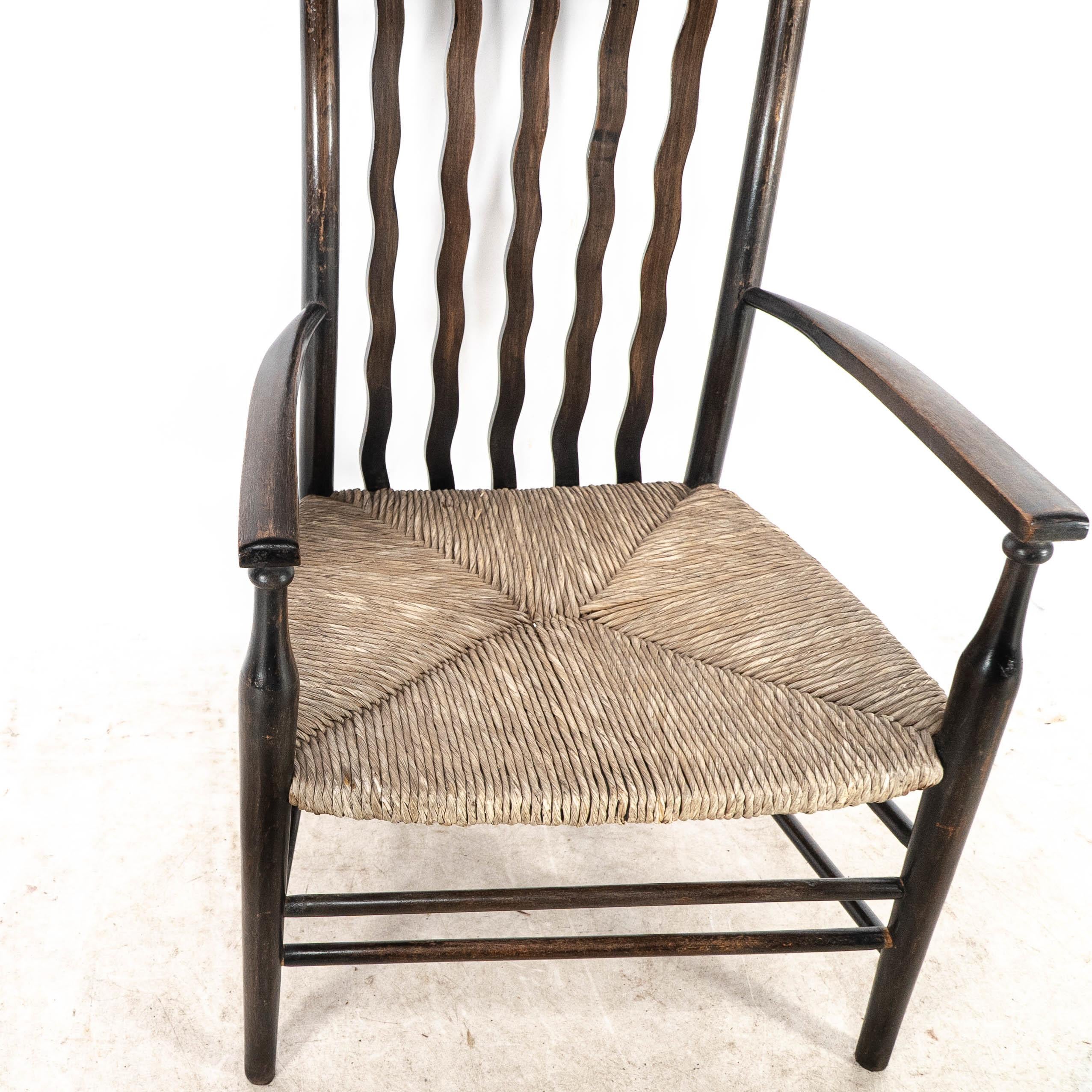 Liberty & Co. An Arts & Crafts rush seat armchair with wavy shaped back slats For Sale 4