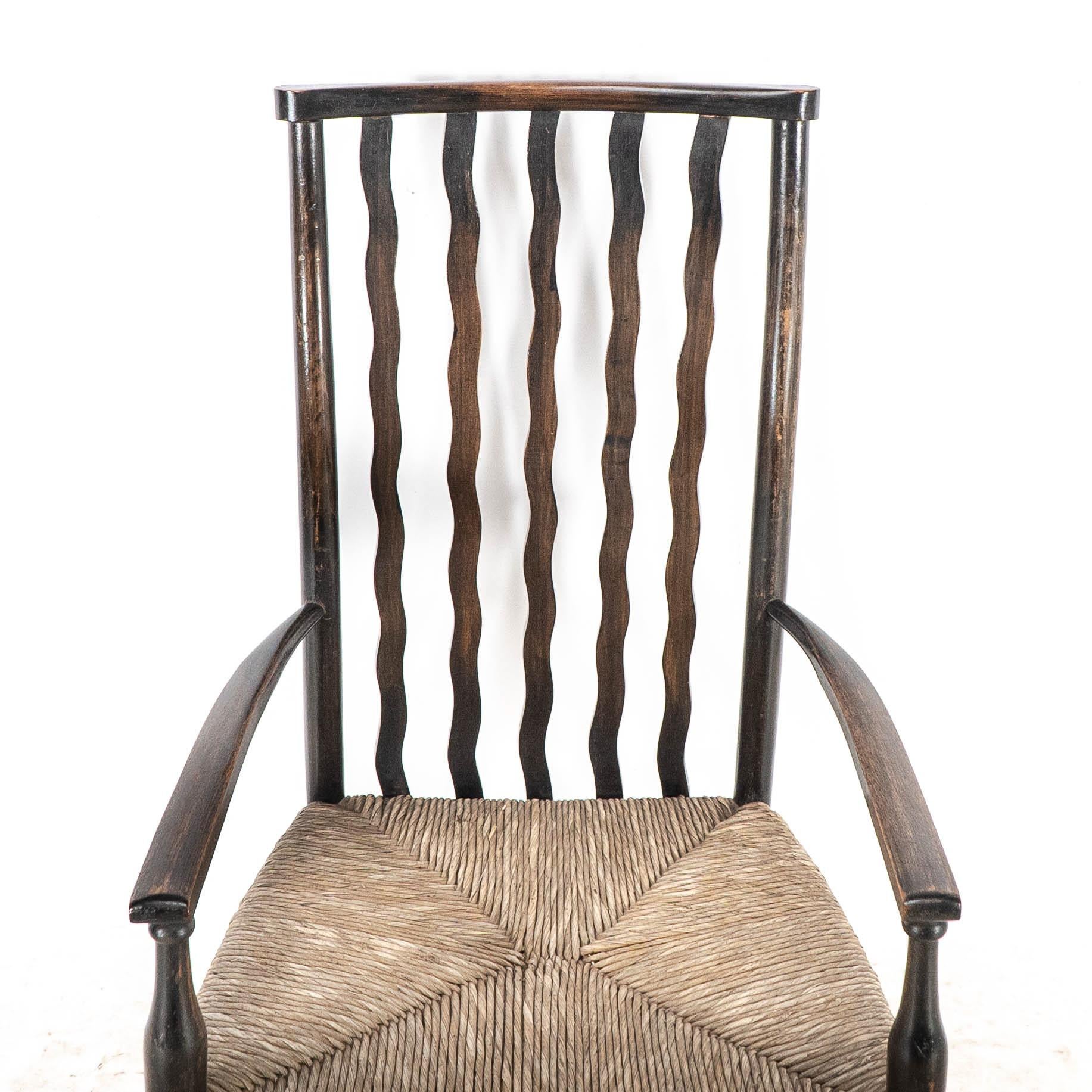 Liberty & Co. An Arts & Crafts rush seat armchair with wavy shaped back slats For Sale 1