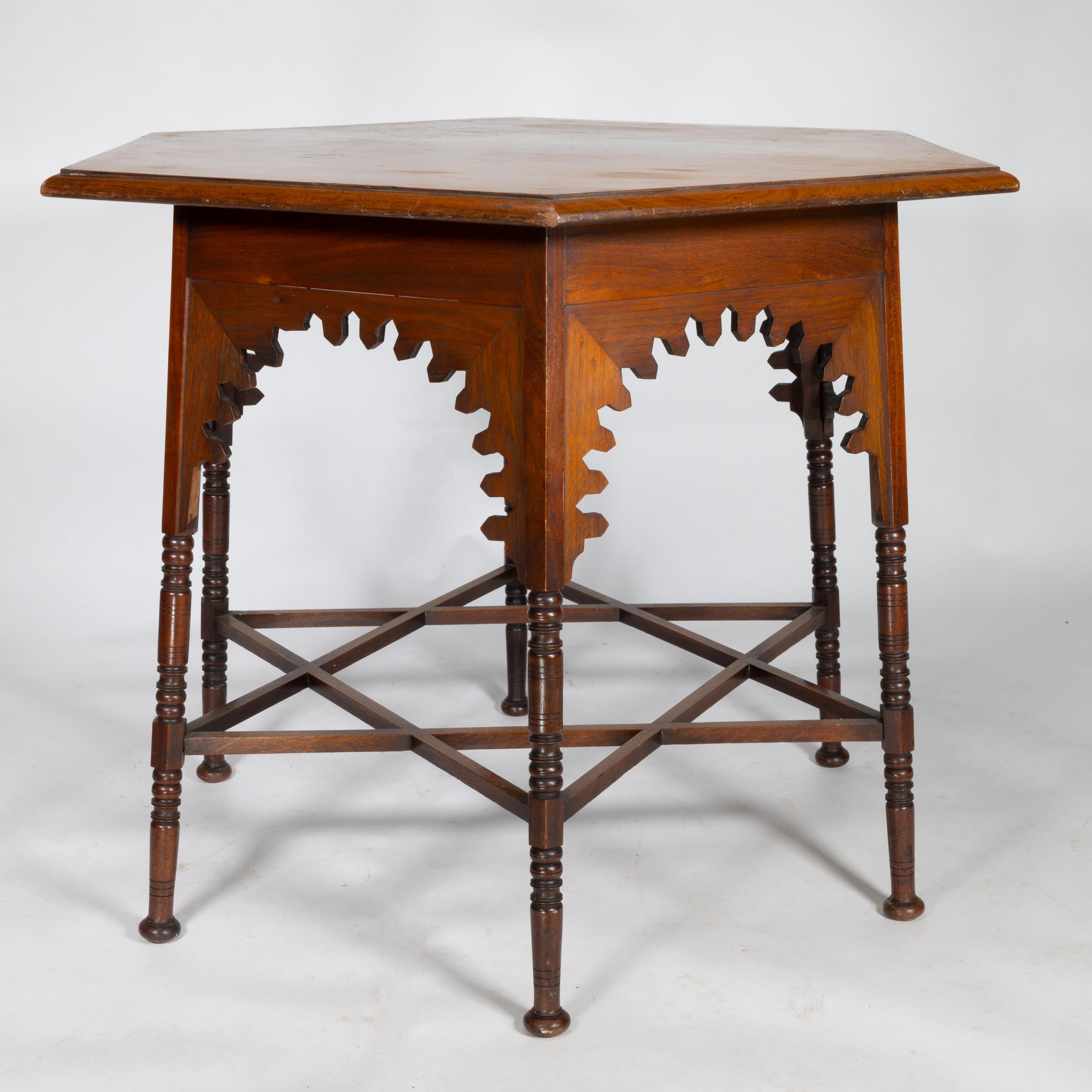 Liberty & Co. An Arts and Crafts walnut centre table with arched apron on ring turned legs united by star shaped stretchers. The period image attached here is variation of the same table taken from Pictorial Dictionary of British 19th Century