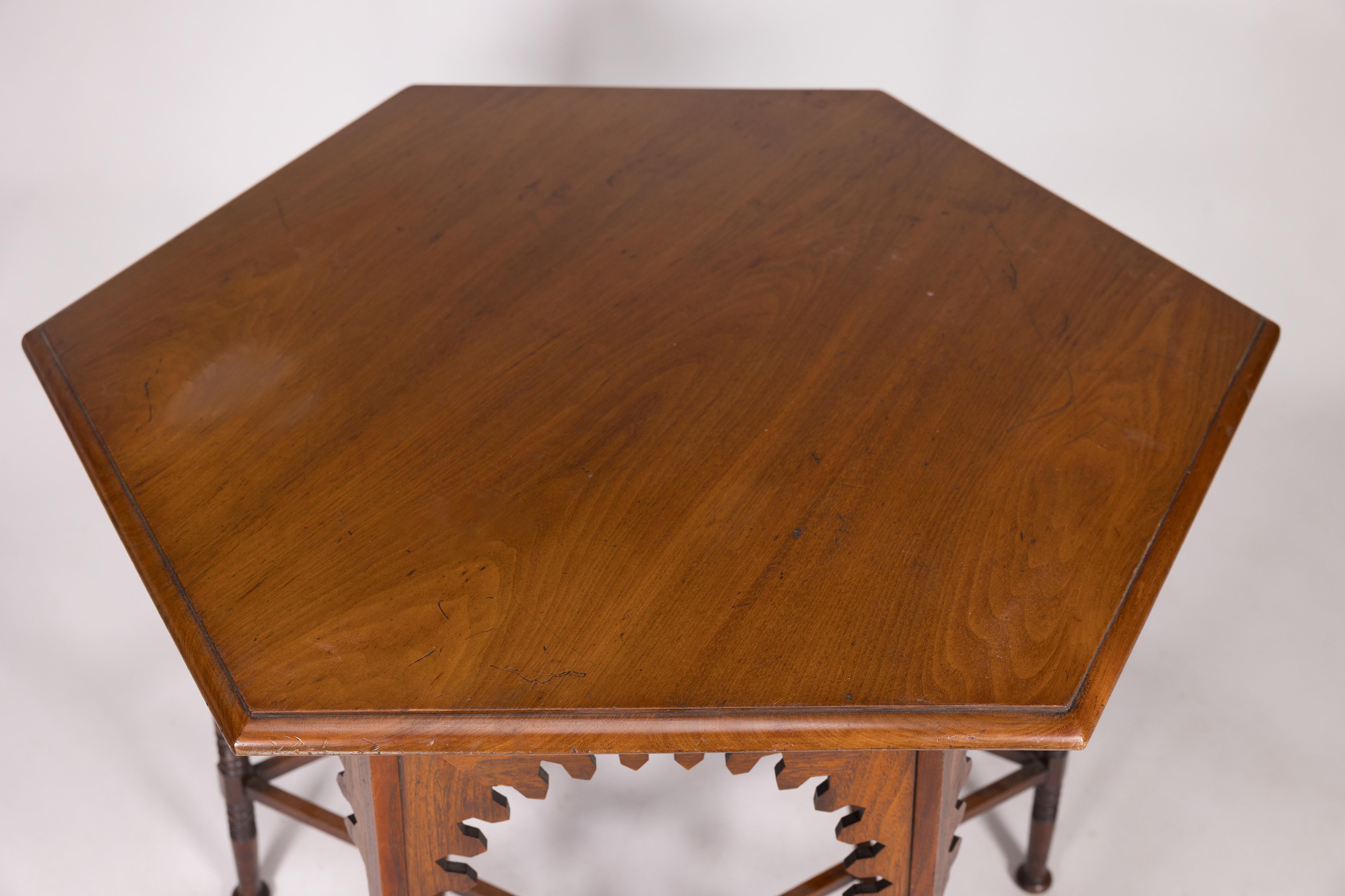 Late 19th Century Liberty & Co. An Arts & Crafts walnut centre table with arched aprons