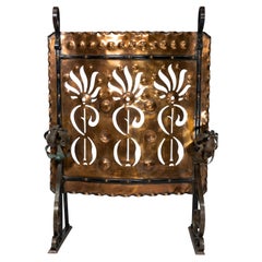 Liberty & Co. An Arts & Crafts wrought iron & copper pierced floral firescreen.