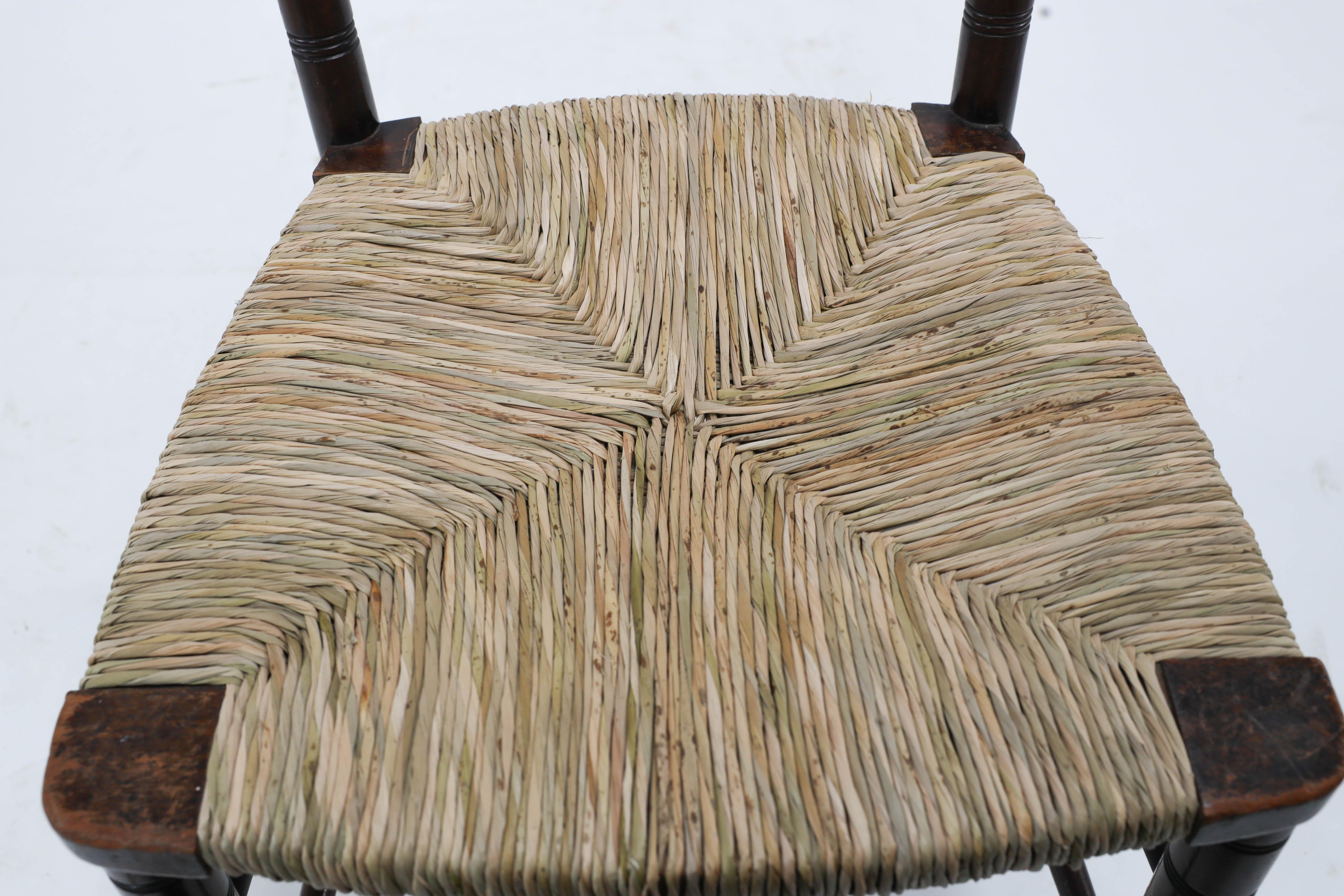 Late 19th Century Liberty & Co. An English Aesthetic Movement walnut ladder back rush seat chair For Sale
