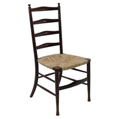 Liberty & Co. An English Aesthetic Movement walnut ladder back rush seat chair