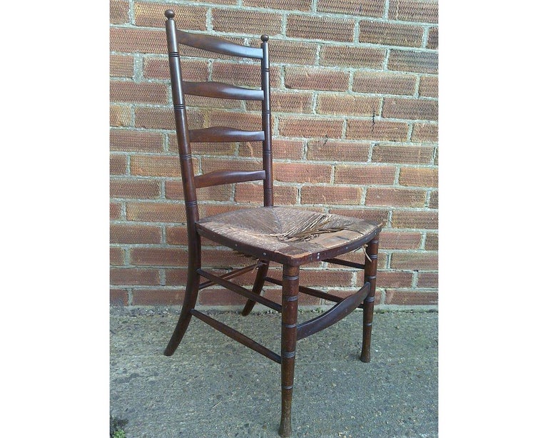 Liberty and Co. 
An English Aesthetic Movement walnut ladder back side chair.
Losses to the rush seat. We can provide new rush seating at £160 which takes 4 weeks.
