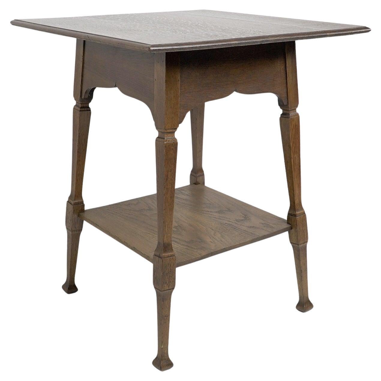 Liberty & Co. An Arts & Crafts oak two tier side table with Moorish aprons. For Sale