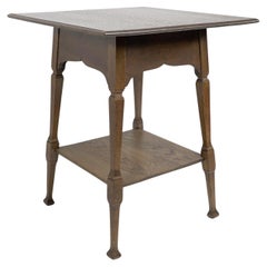 Antique Liberty & Co. An oak two tier side table with a Moorish apron underneath the top