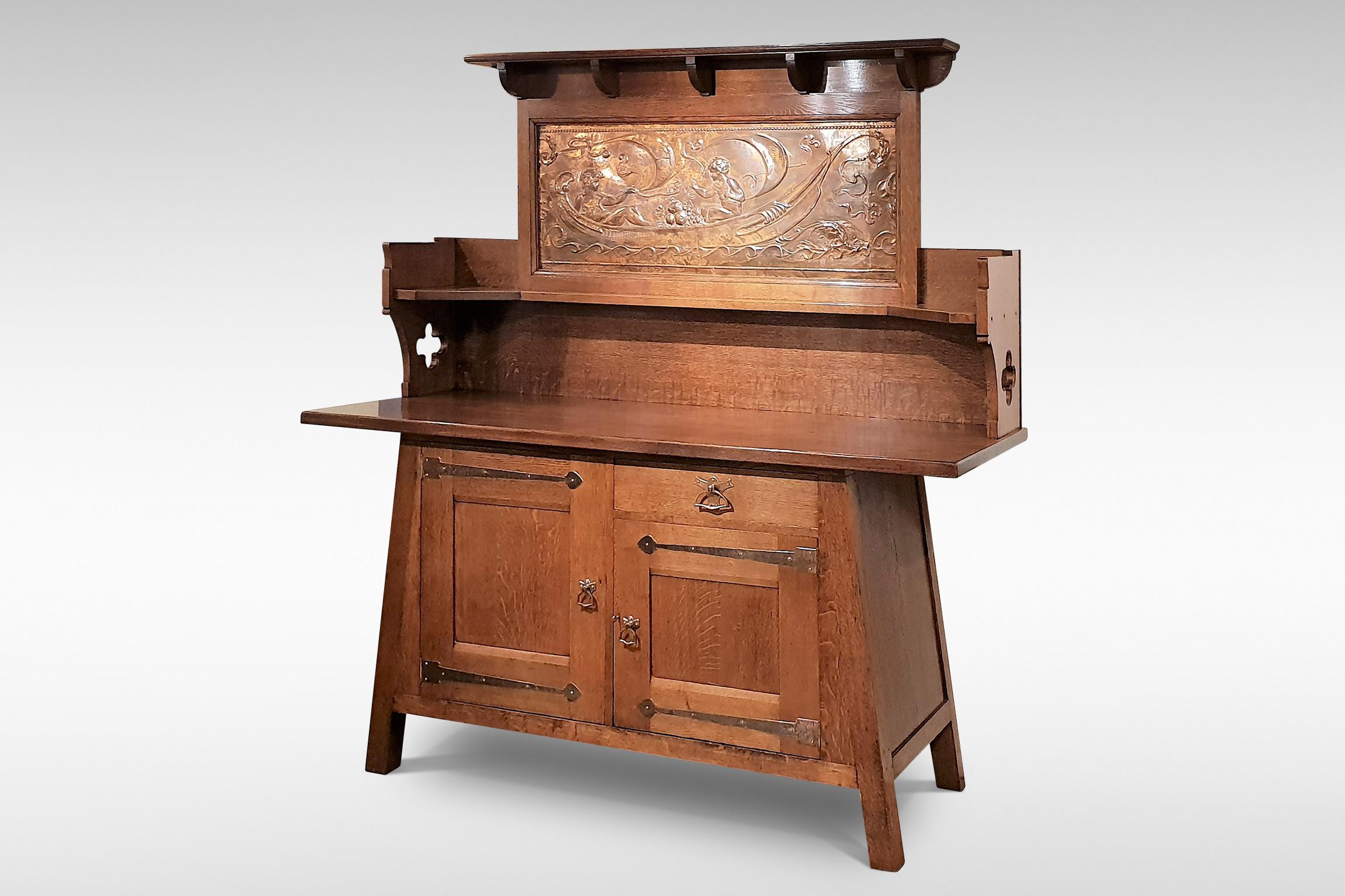 A superb example of Arts & Crafts design, possibly by Leonard Wyburd. It is in oak with a large copperised metal plaque, copper handles and hand-beaten hinges,
circa 1895-1900

The Witlaf sideboard first appears in the Liberty & Co 'Handbook of