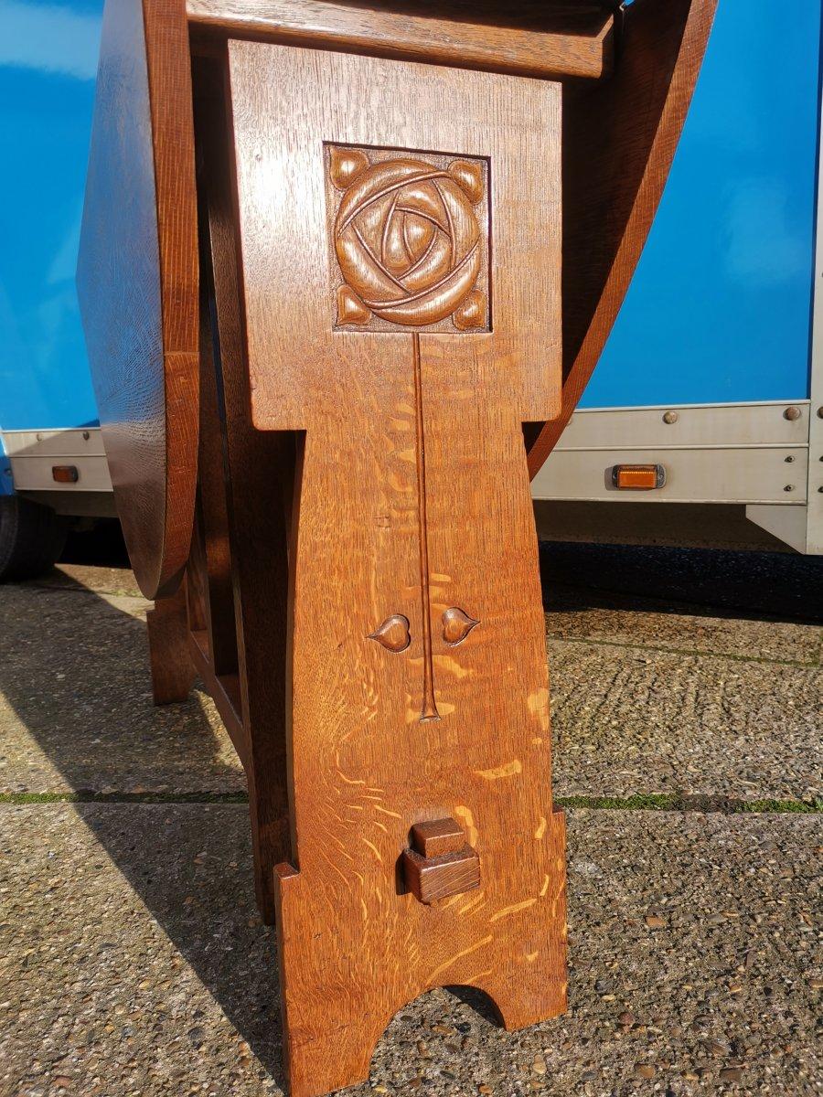 English Liberty & Co, Arts & Crafts Oak Dropleaf Table with Stylized Carved Flower Head For Sale