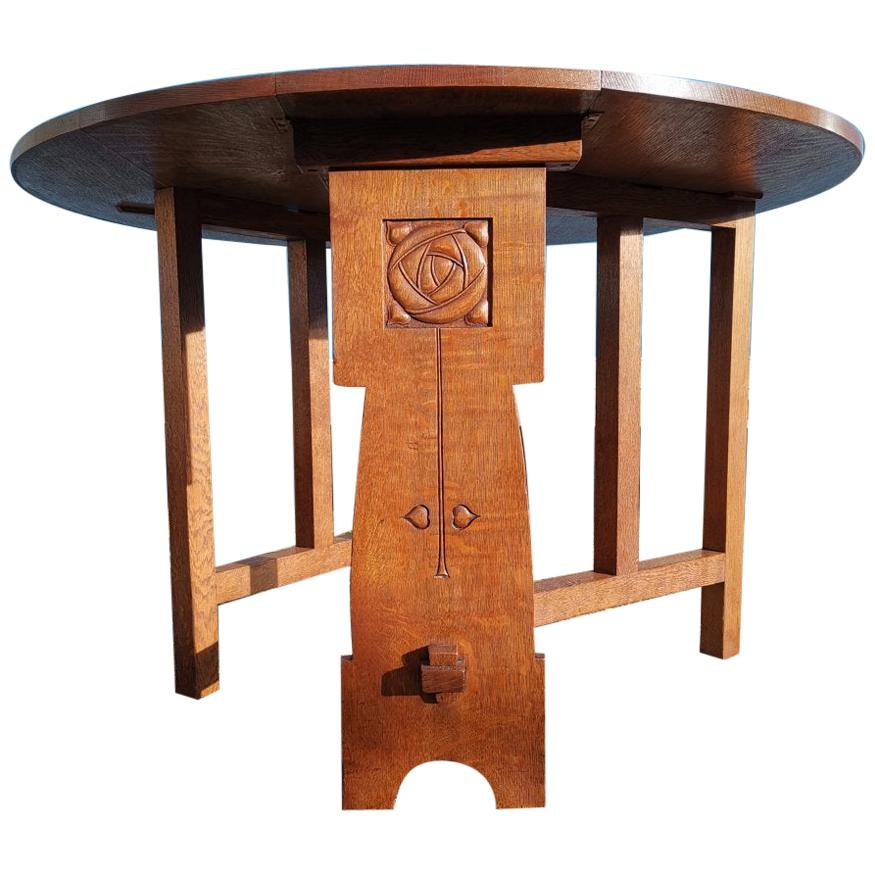 Liberty & Co, Arts & Crafts Oak Dropleaf Table with Stylized Carved Flower Head For Sale