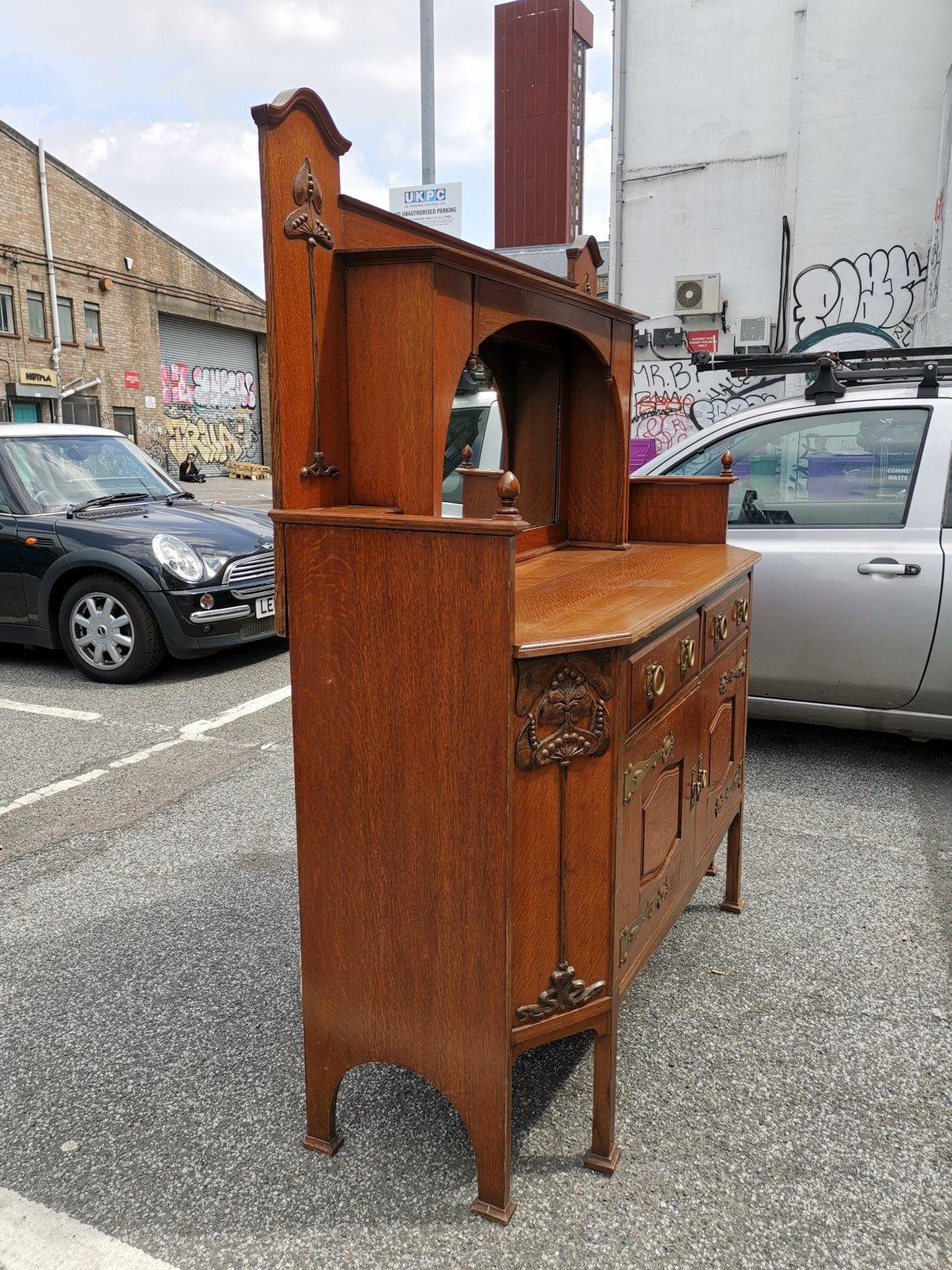 Beveled Liberty & Co Attr. An English Arts & Crafts Oak Sideboard with Carved Decoration For Sale