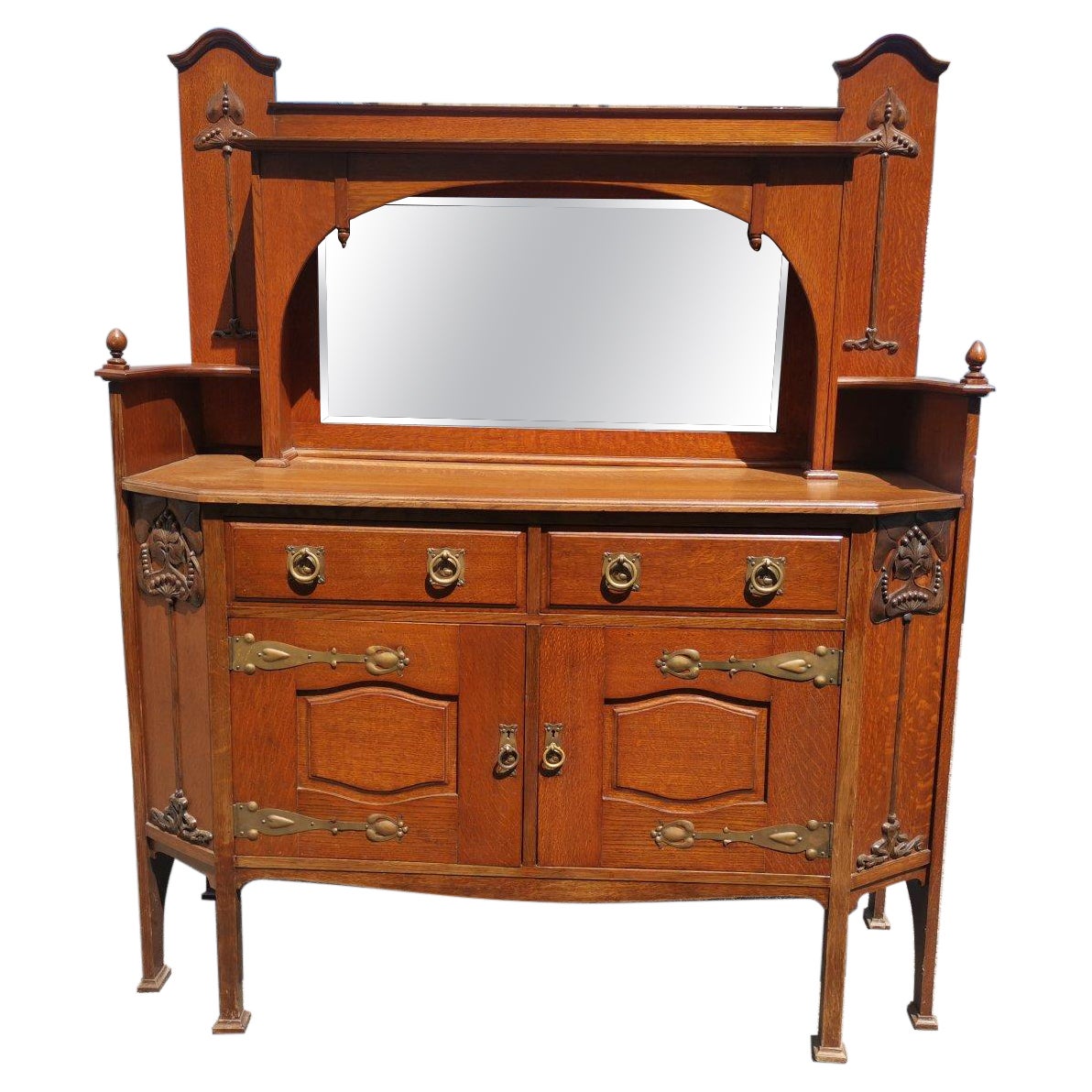 Liberty & Co. Una credenza inglese in legno di quercia di tipo Arts & Crafts con decorazioni intagliate