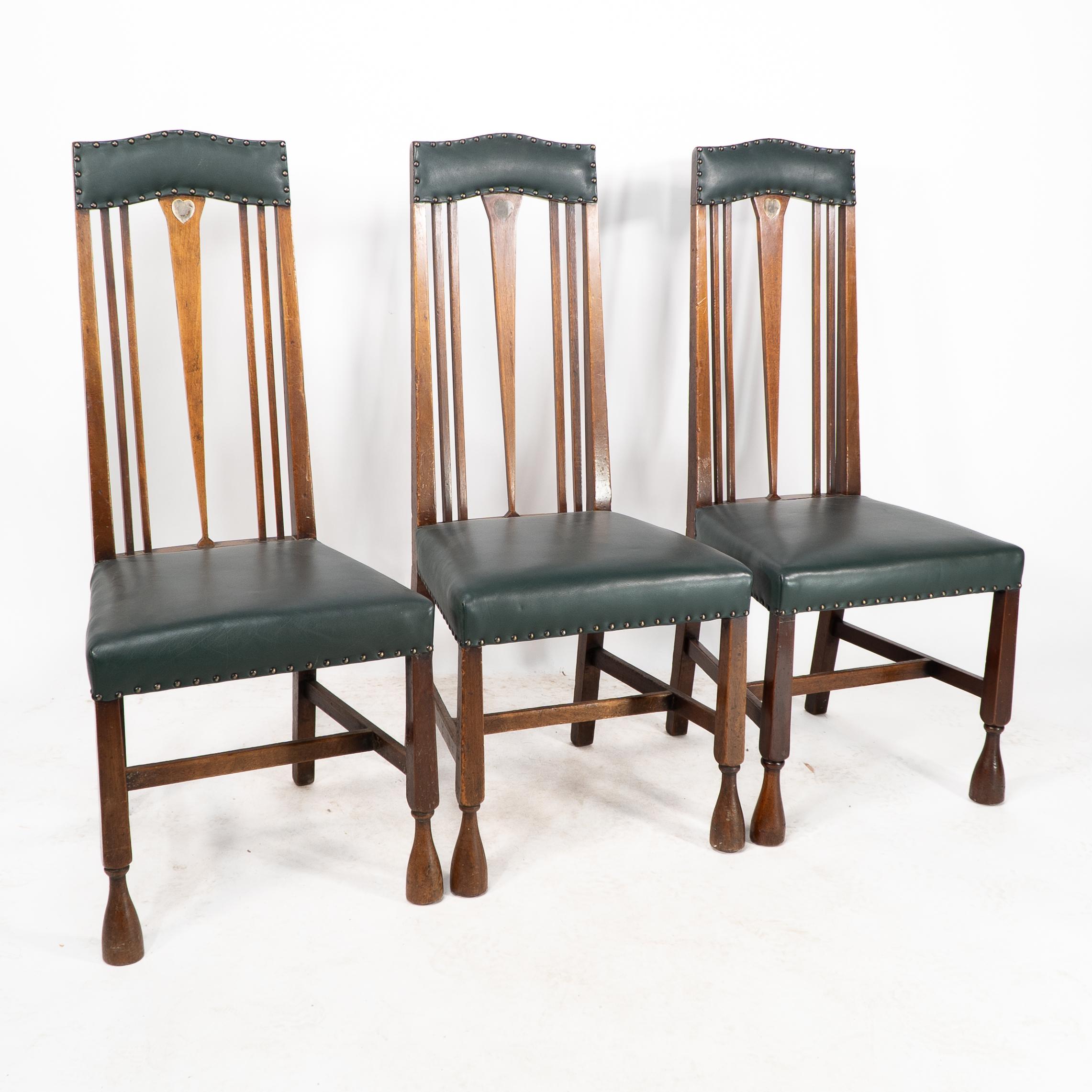Liberty & Co. Tre sedie abbinate con poggiatesta sagomato e imbottito e un cuore in peltro intarsiato in stile Voysey sulla sommità di uno schienale affusolato con piedi a tromba. Prezzo per sedia. È disponibile anche una versione singola abbinata