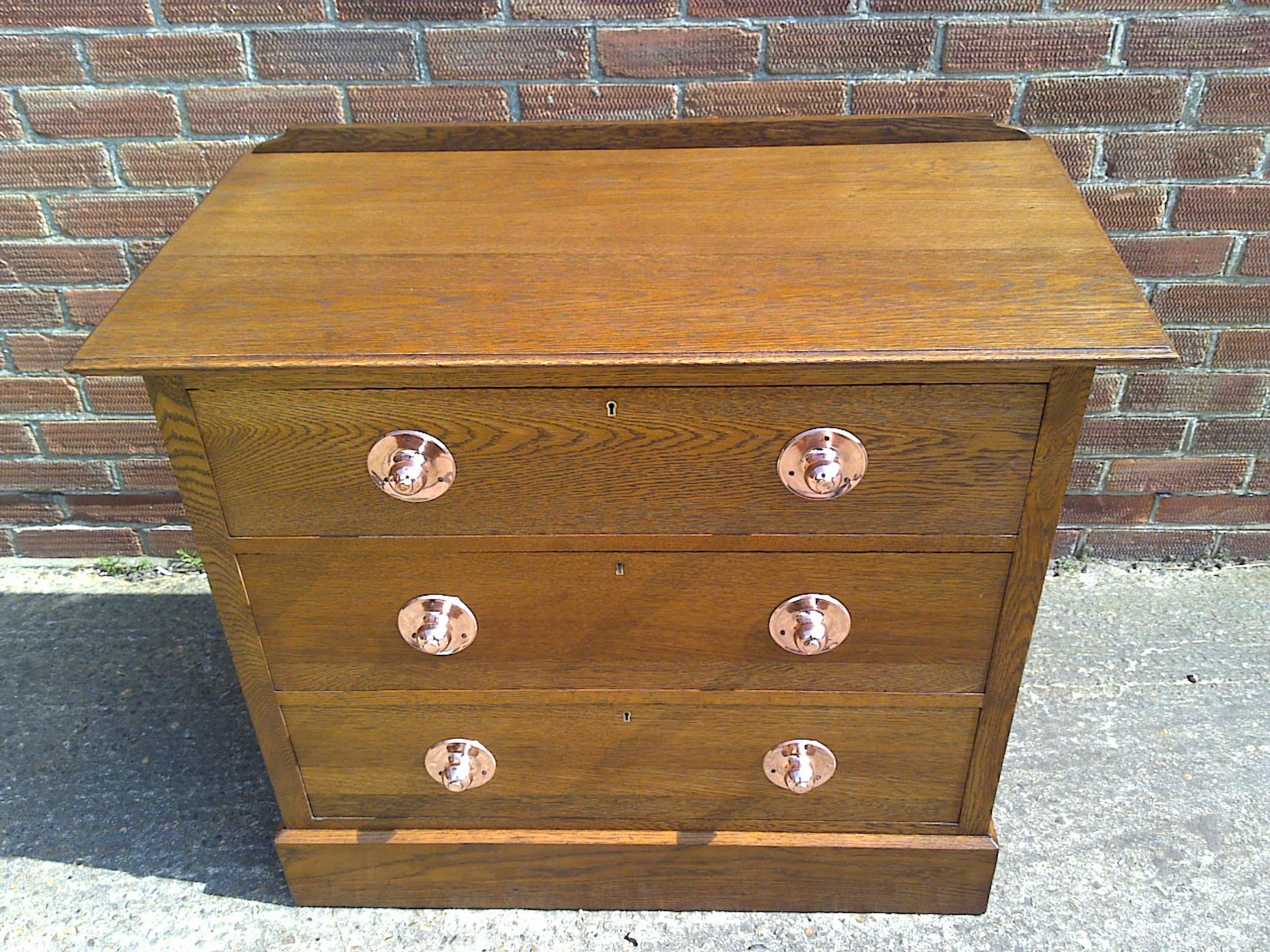 Liberty & Co attributed.
A good quality Arts and Crafts oak chest of three drawers of small proportions with circular copper handles.