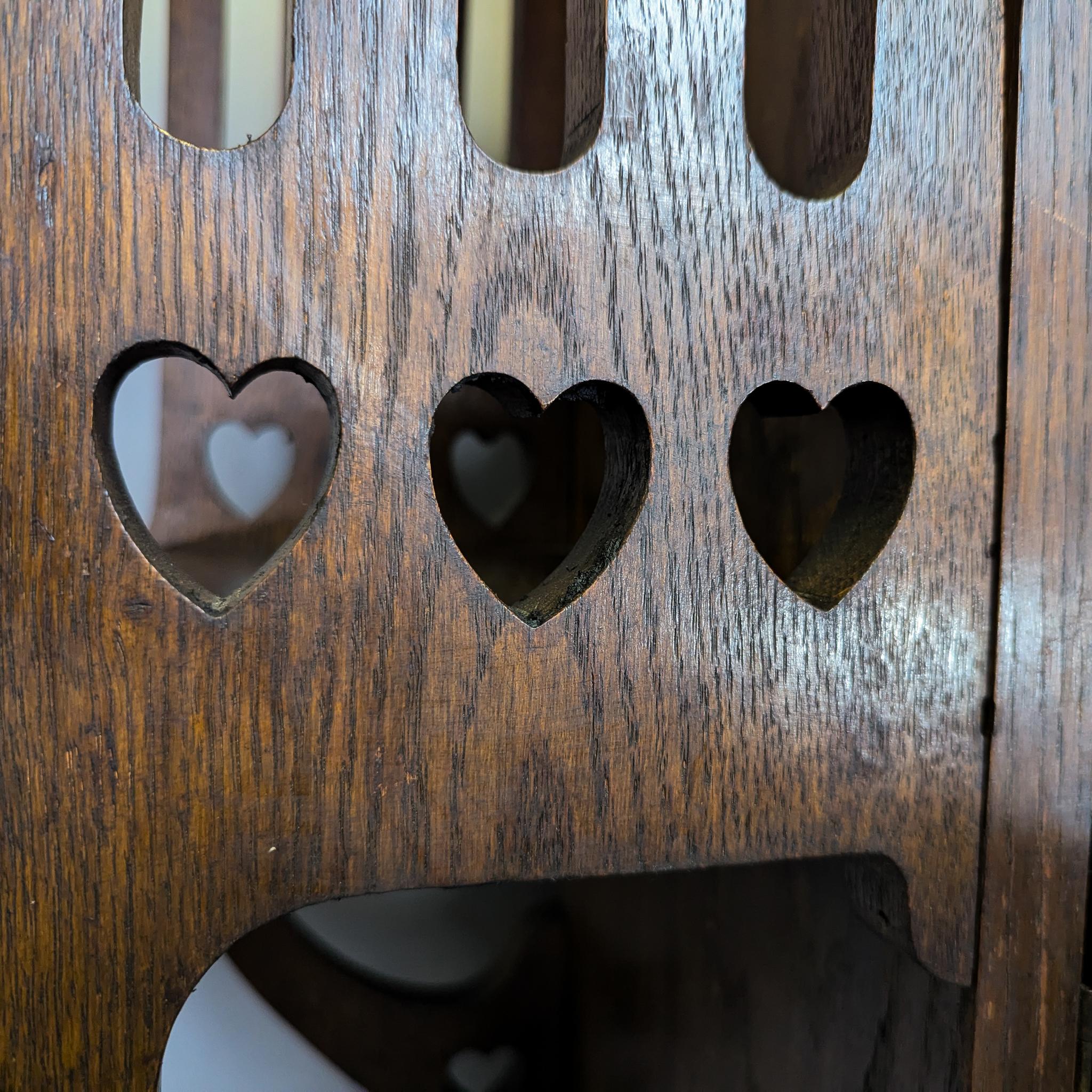 Liberty & Co., atribuido
Librería Arts and Crafts de roble acristalado con una zona de exposición plana de buen tamaño encima, una cornisa abocinada con una zona de exposición abierta superior debajo, y un espejo en la parte trasera con corazones