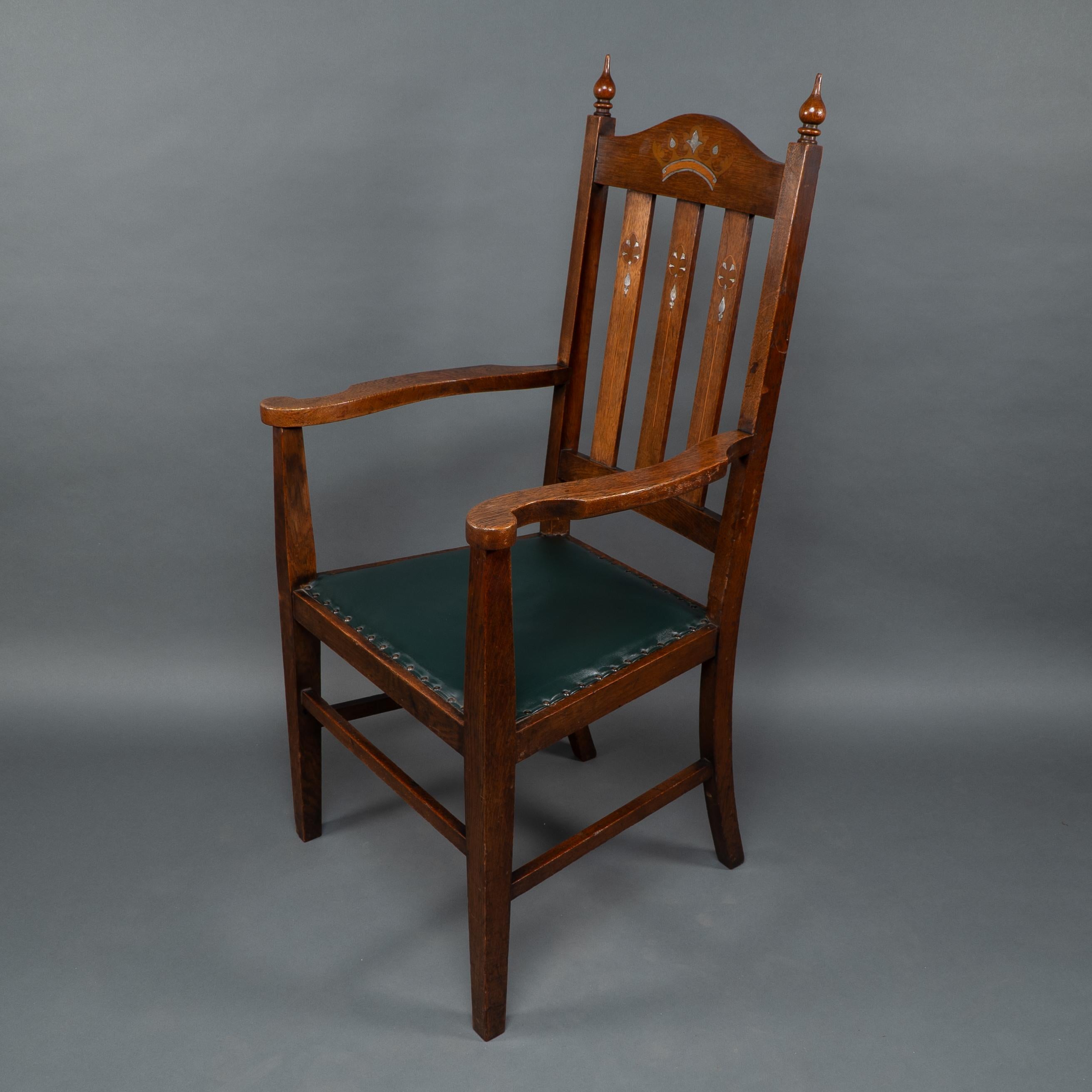 Atribuido a Liberty & Co. Un sillón Arts & Crafts de roble con corona real incrustada Artes y manualidades en venta