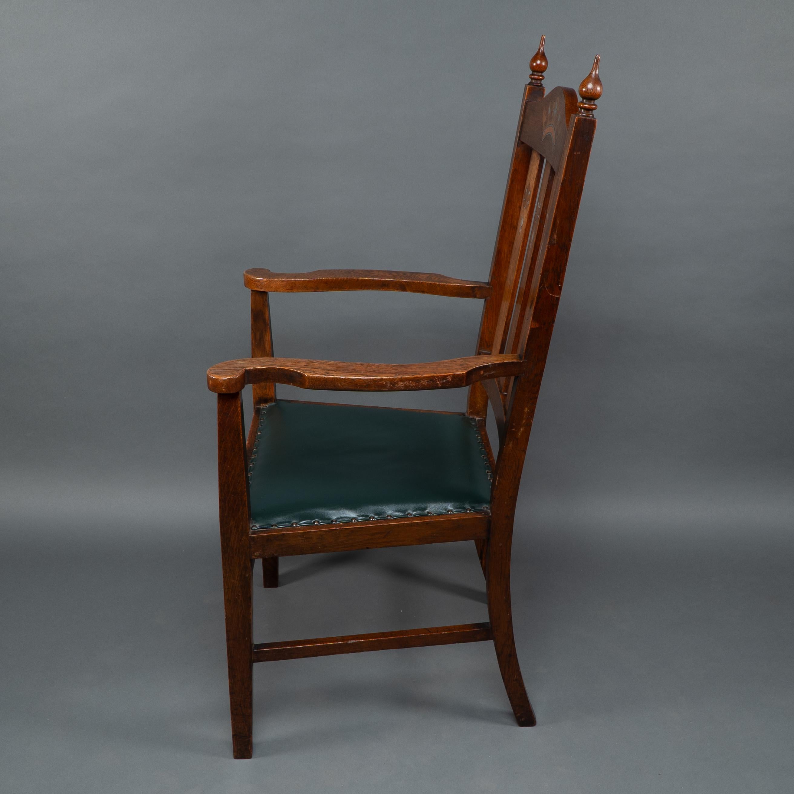 Atribuido a Liberty & Co. Un sillón Arts & Crafts de roble con corona real incrustada Inglés en venta