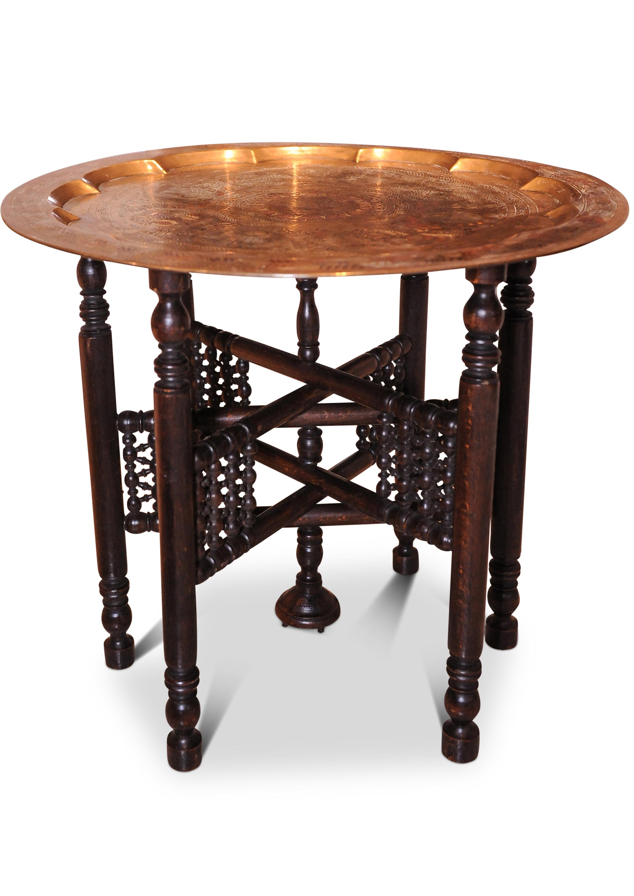 Superbe Liberty & Co. du début du 20e siècle. Table à thé pliante en laiton et bois dur, décorée de paons en émail et d'ornements en émail, fabriquée au Moyen-Orient

Les motifs répétitifs, à la fois décoratifs et géométriques complexes, donnent
