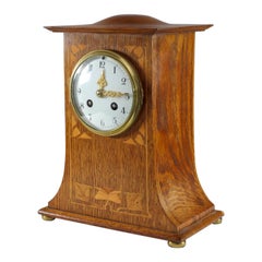 Liberty & Co C F A Voysey style Arts & Crafts horloge de cheminée en chêne avec incrustation florale.
