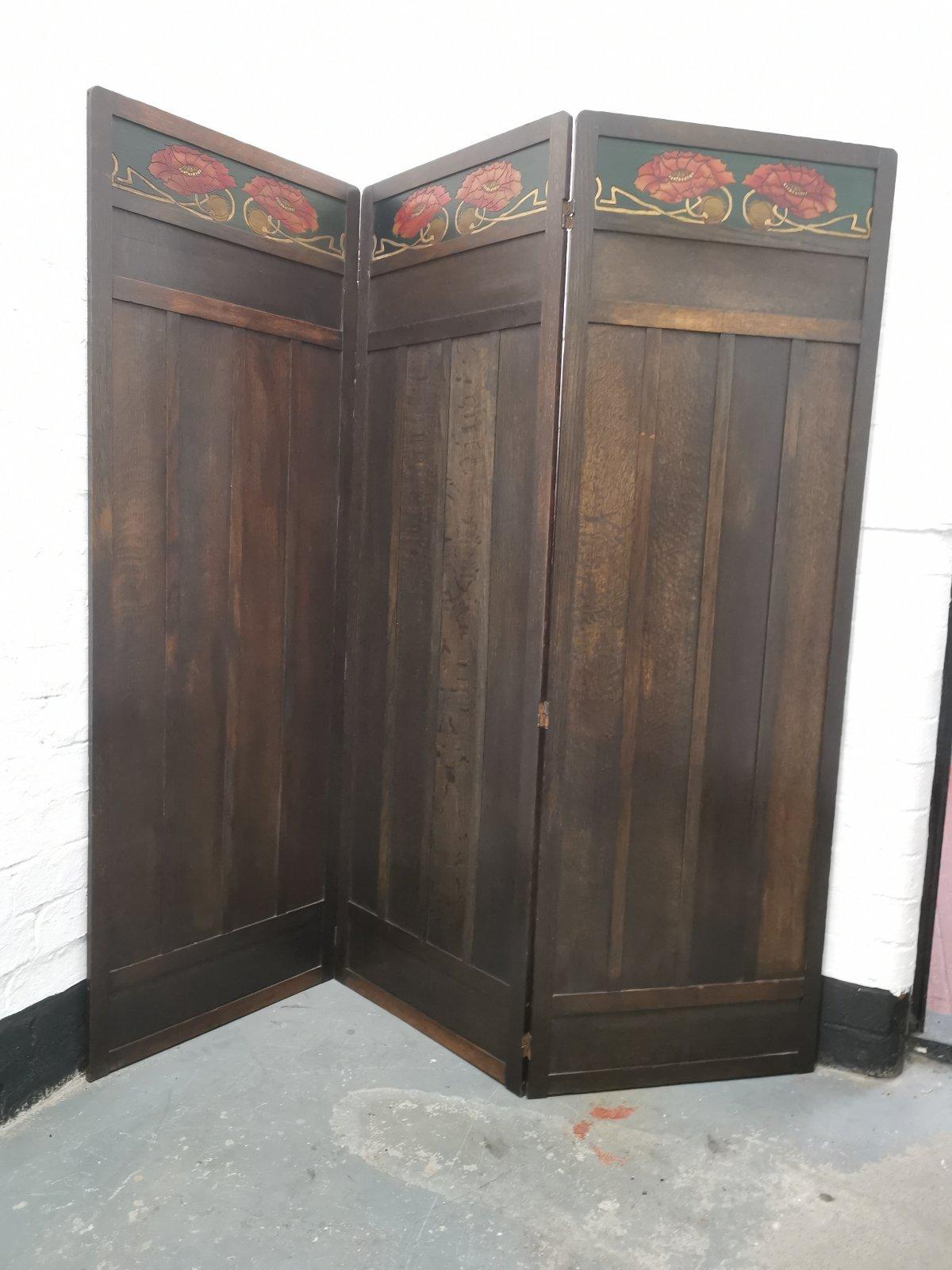 Liberty & Co. An English Arts & Crafts three-fold panelled oak screen with stylized carved and painted floral details to the top.
The height is 58 inches, fully extended it measures 59 inches, each panel is 19.75inches wide and 1/2 an inch thick.