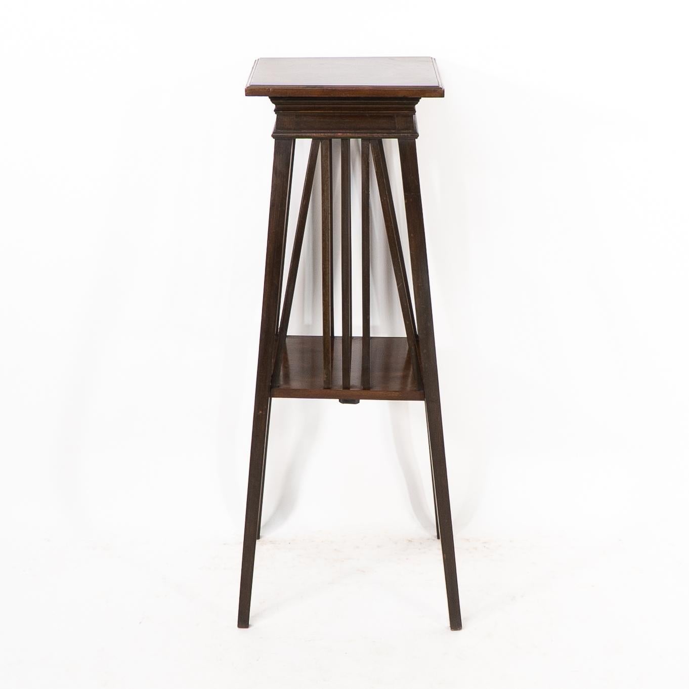 Liberty & Co. nello stile di E W Godwin. Un portapiante anglo-giapponese a due livelli con grembiule sagomato sotto la parte superiore. Un supporto per piante ben progettato, dall'elegante forma affusolata.