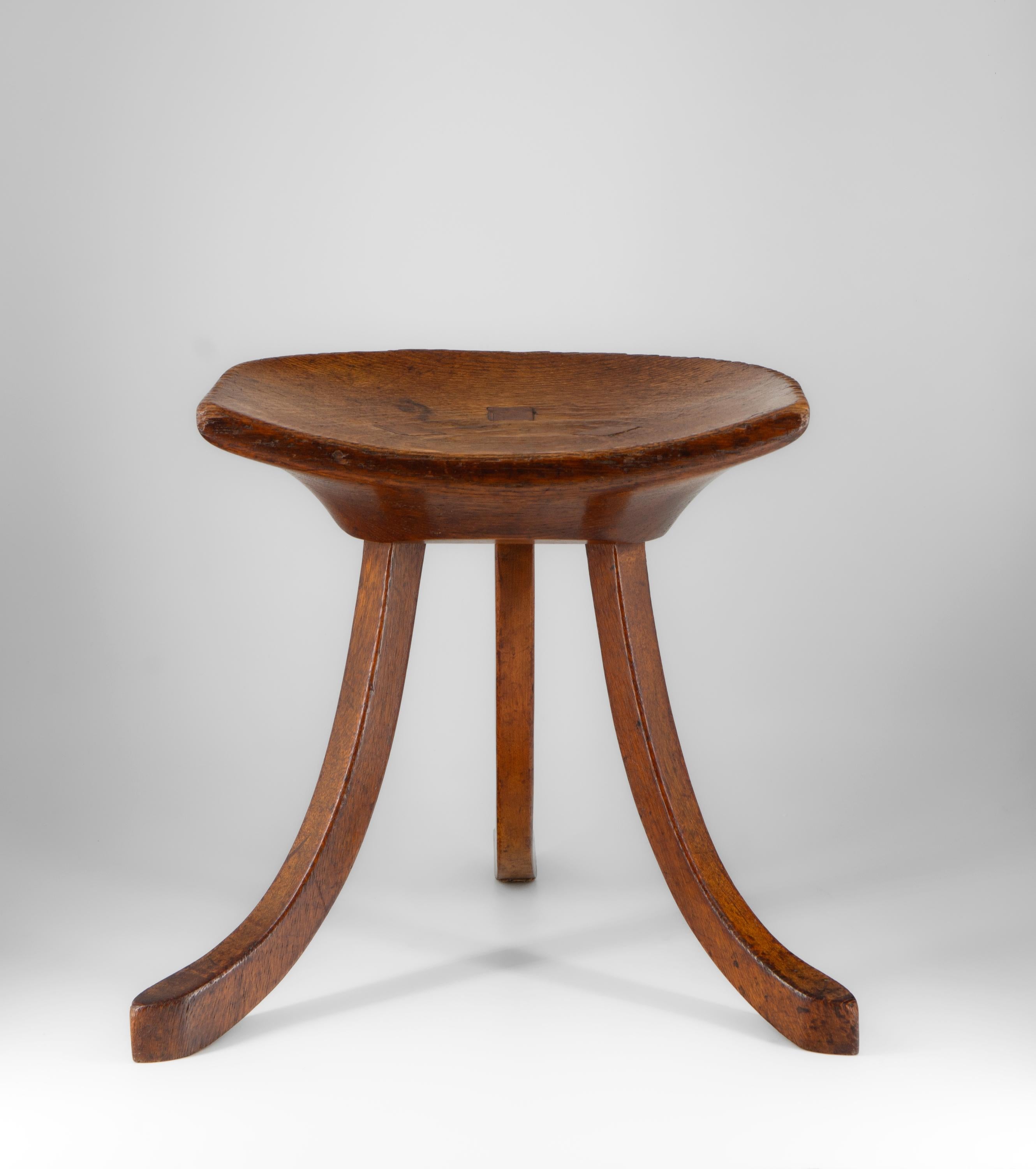 A Liberty & Co oak Thebes stool. Circa 1915.

The stool has a dished seat raised on three splayed supports and retains the original finish, which has been lightly waxed. It is a good example with no damage or repairs. Showing signs of use, the top