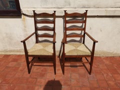 Liberty & Co. Style of CFA Voysey. A Pair of Oak Rush Seat Ladderback Armchairs