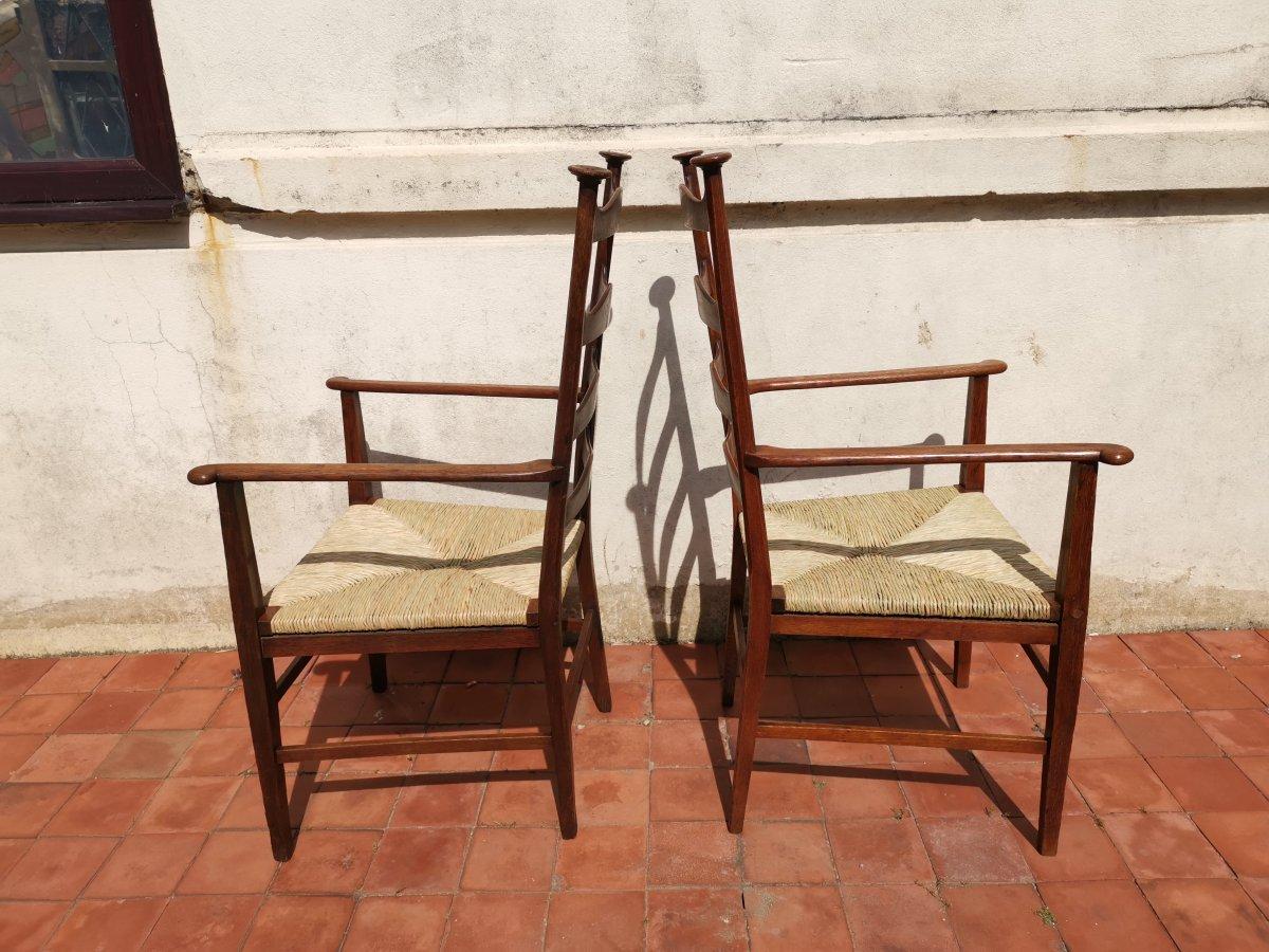 English Liberty & Co. Style of CFA Voysey. A Pair of Oak Rush Seat Ladderback Armchairs For Sale