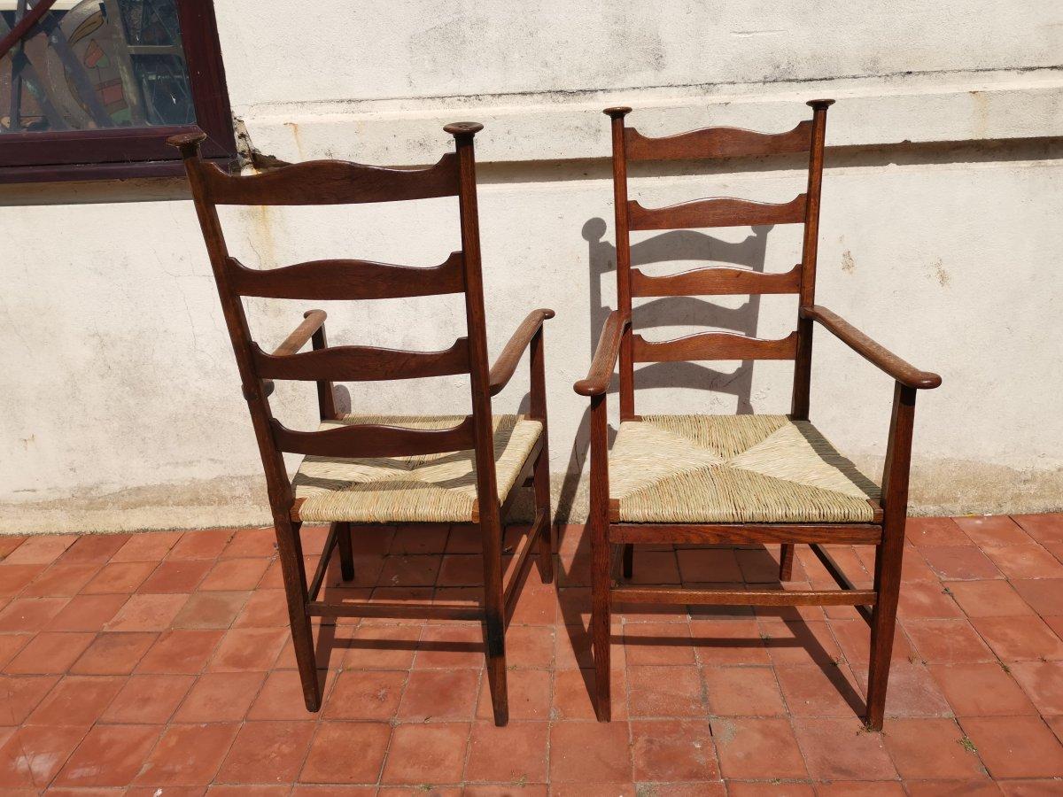 Early 20th Century Liberty & Co. Style of CFA Voysey. A Pair of Oak Rush Seat Ladderback Armchairs For Sale