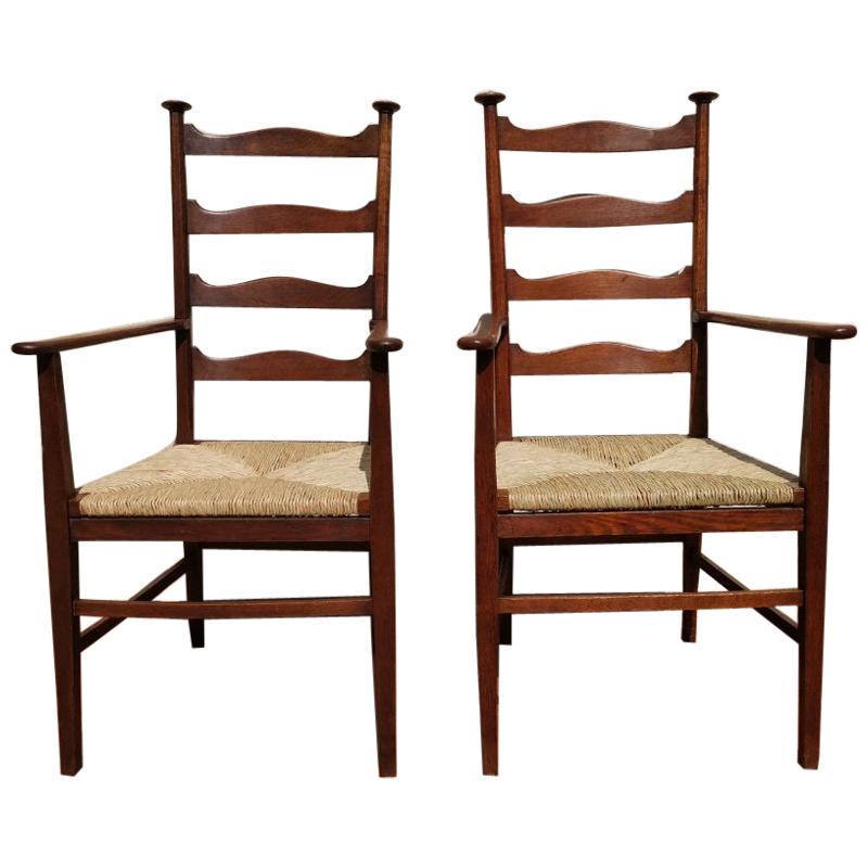 Liberty & Co. Style of CFA Voysey. A Pair of Oak Rush Seat Ladderback Armchairs For Sale