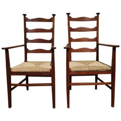 Antique Liberty & Co. Style of CFA Voysey. A Pair of Oak Rush Seat Ladderback Armchairs