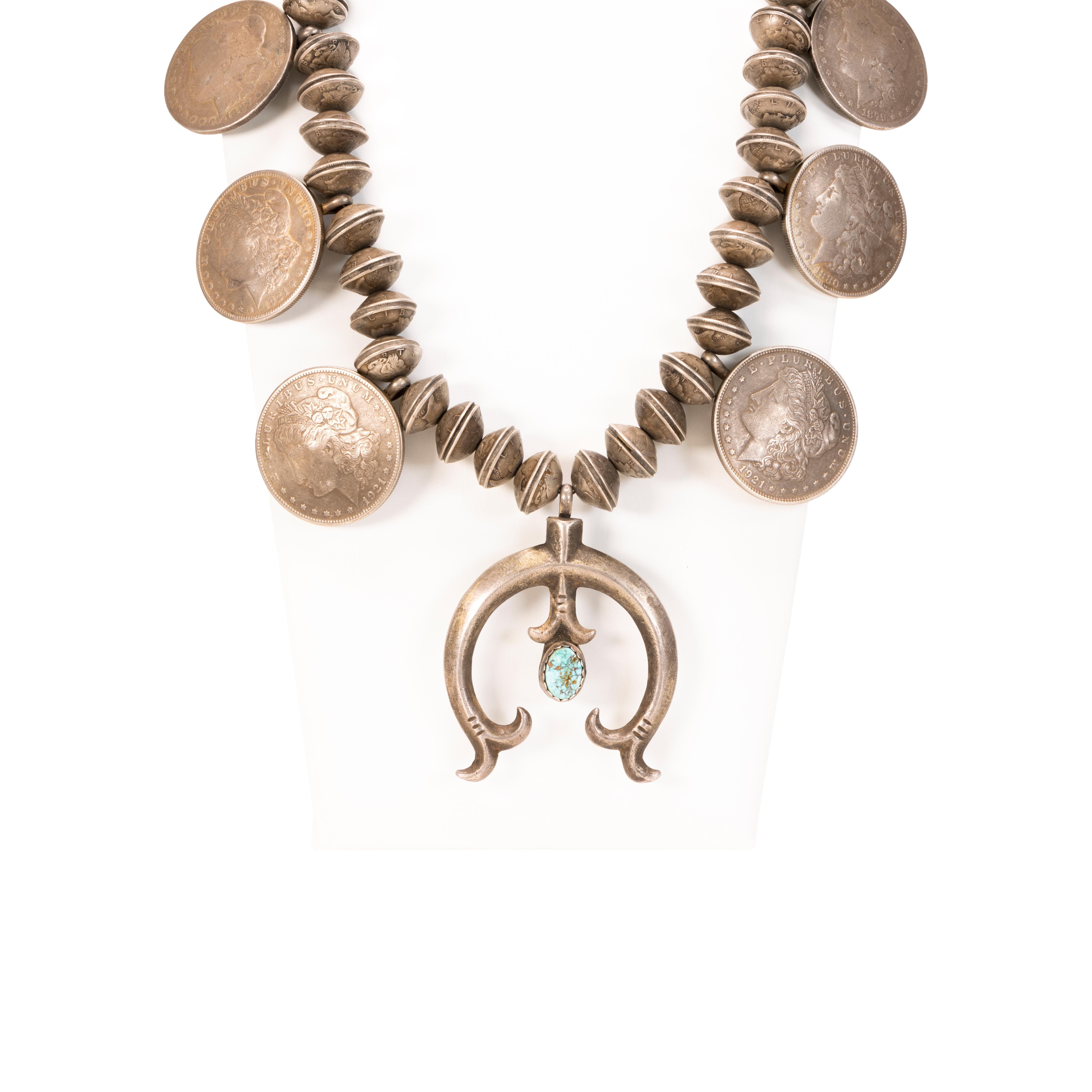 Navajo turquoise and sterling silver squash blossom necklace made from soldered mercury dime, or winged Liberty Head dimes with sand cast naja containing a small turquoise stone. The earliest coin dates 1879 and latest dates 1931. These mercury