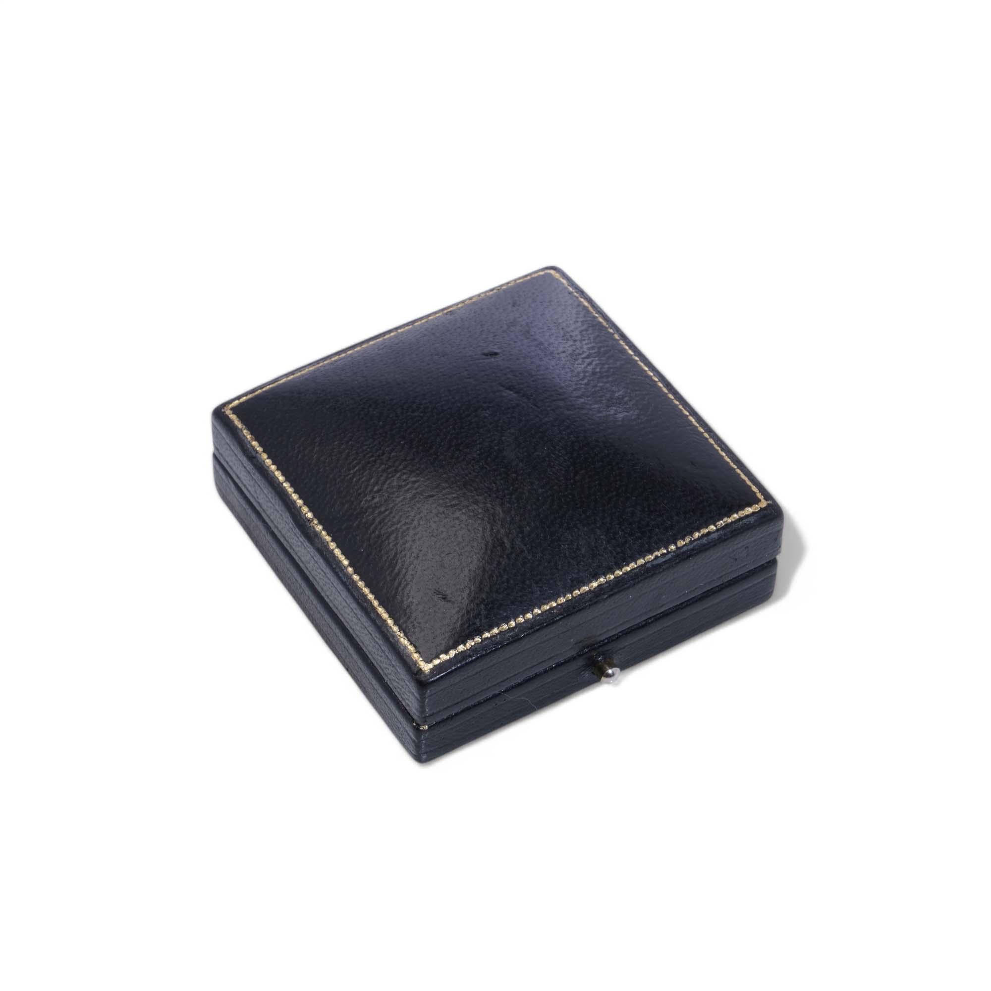 Broche Libertad Caja

Periodo: Principios a mediados del siglo XX
Material: Exterior de cuero negro con tapa de satén crema y base de terciopelo negro
Finalidad: Diseñado para guardar y presentar anillos
Dimensiones: 6 x 5,7 x 2,3 cm
Estado: Bueno;