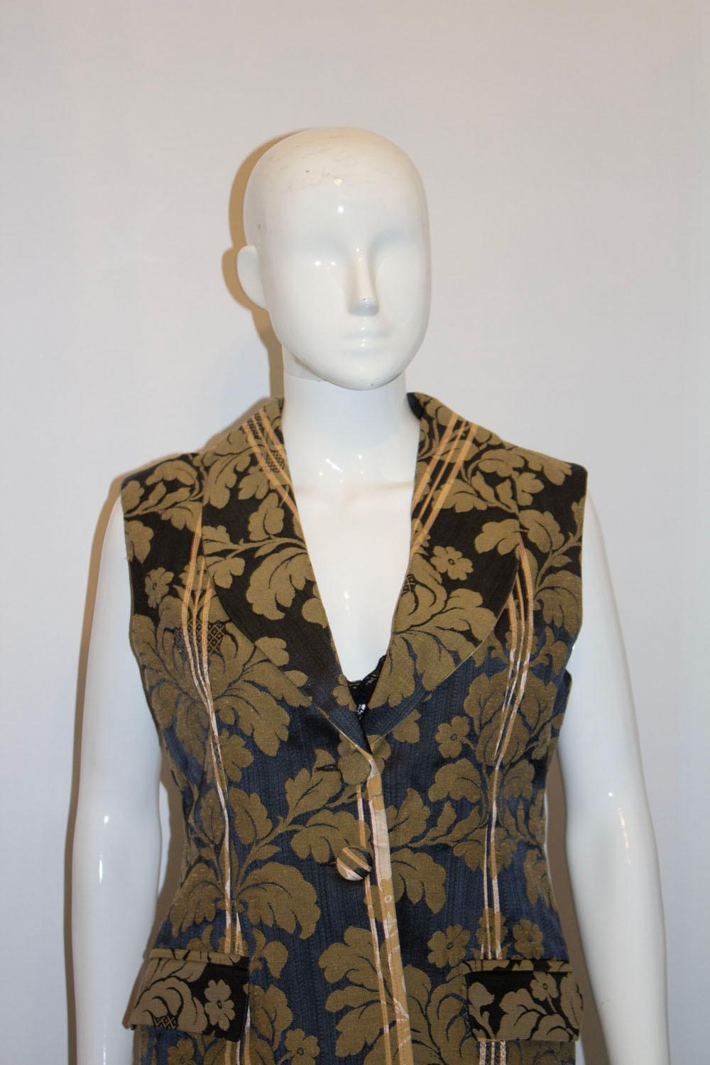 A stunning and useful black and gold waistcoat by Liberty of London. In an attractive black and gold fabric, the waistcoat has a v neckline and two button opening. It is fully lined and has a pocket on either side.  Size 12 .
Measurements  Bust up