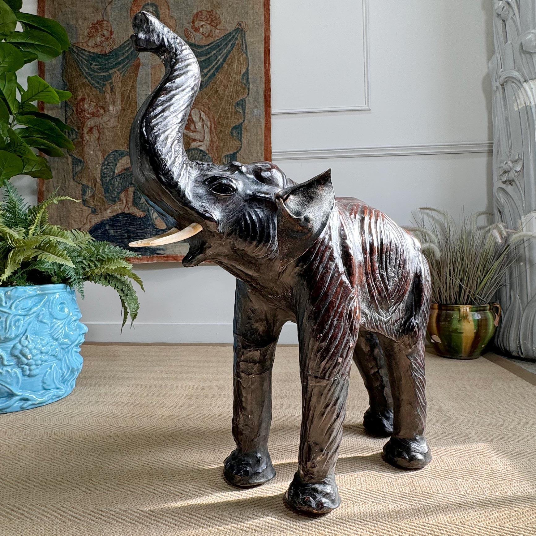 Un magnifique pouf en cuir fauve, modelé comme un éléphant, la tête tournée vers le haut et la trompe tendue vers le ciel, avec de larges yeux en verre et de grandes oreilles, incroyablement détaillé et d'une qualité exceptionnelle. Attribué à