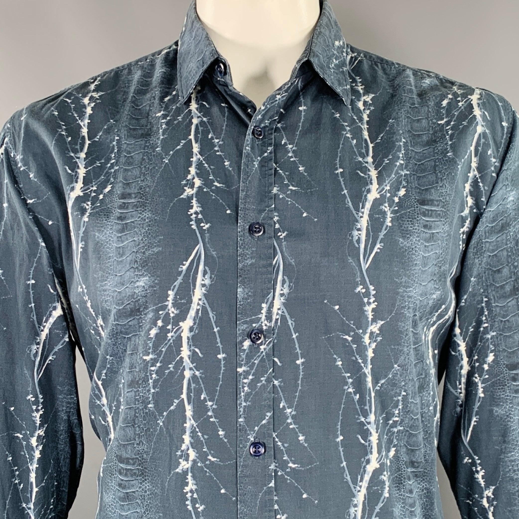 Camicia a maniche lunghe di LIBERTY OF LONDON
in tessuto di cotone navy con stampa astratta a strisce di pelle di serpente e dettagli marmorizzati bianchi e chiusura con bottoni. Made in Italy. Eccellente condizione di usato. 

Contrassegnato:  