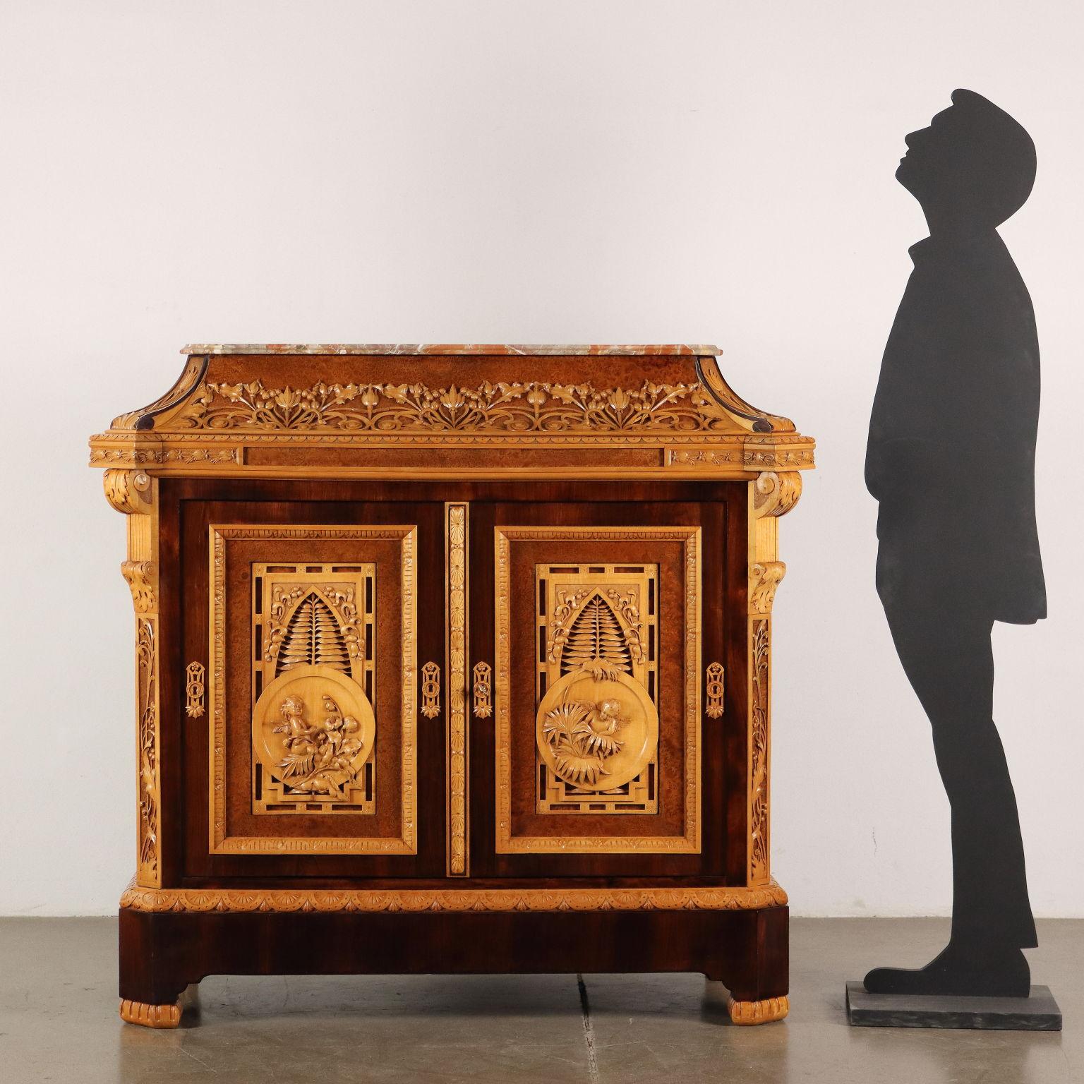 Carved sideboard with urn-shaped riser, antique breccia top, front with two doors, uprights at 45 degrees. The whole structure of the piece of furniture is veneered with Indian walnut, thuya briar and is richly carved with maple worked with floral