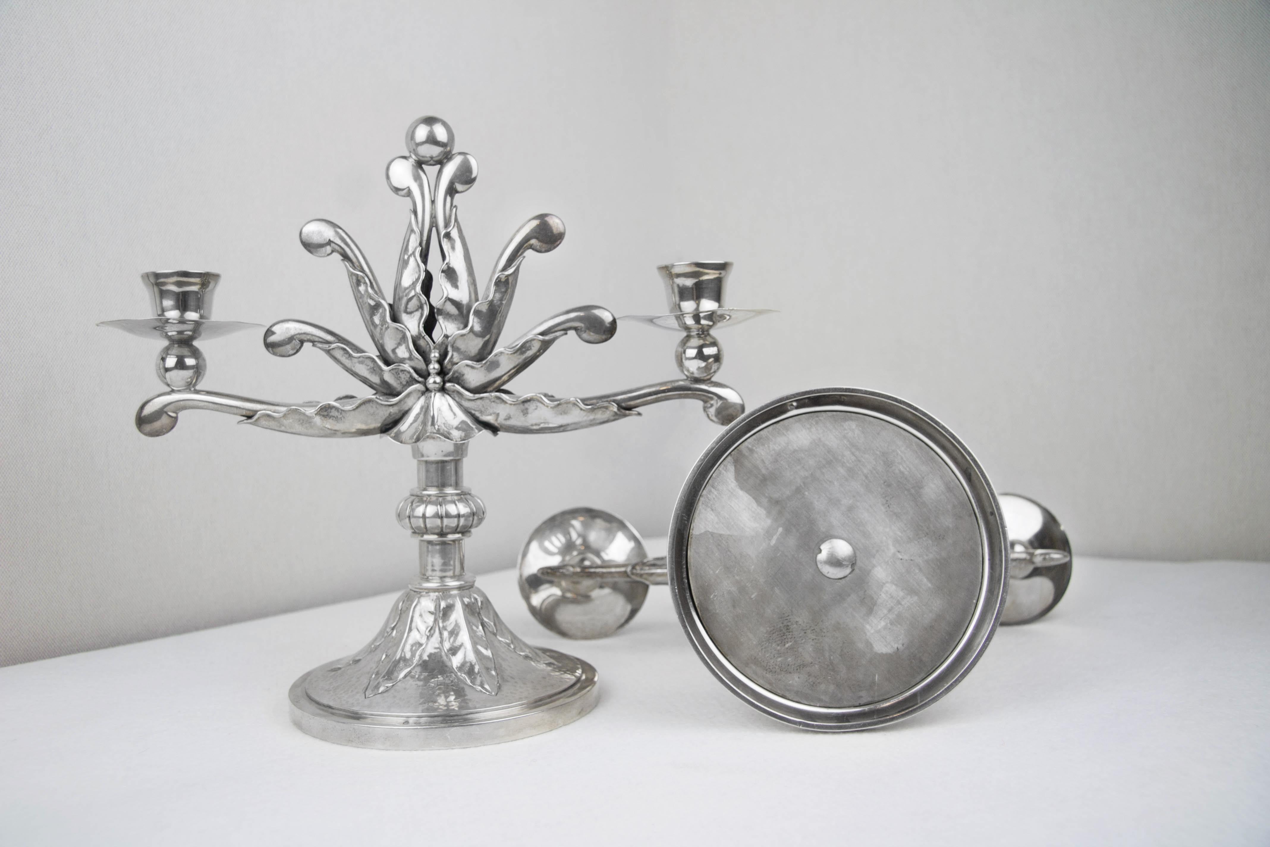 Pair of beautiful sterling silver candlesticks, with the mark of silverware dating back to the beginning of the 20th century. The work of jewelry is particularly elegant, the floral inspiration, which is reflected in the polylobolate stem in the