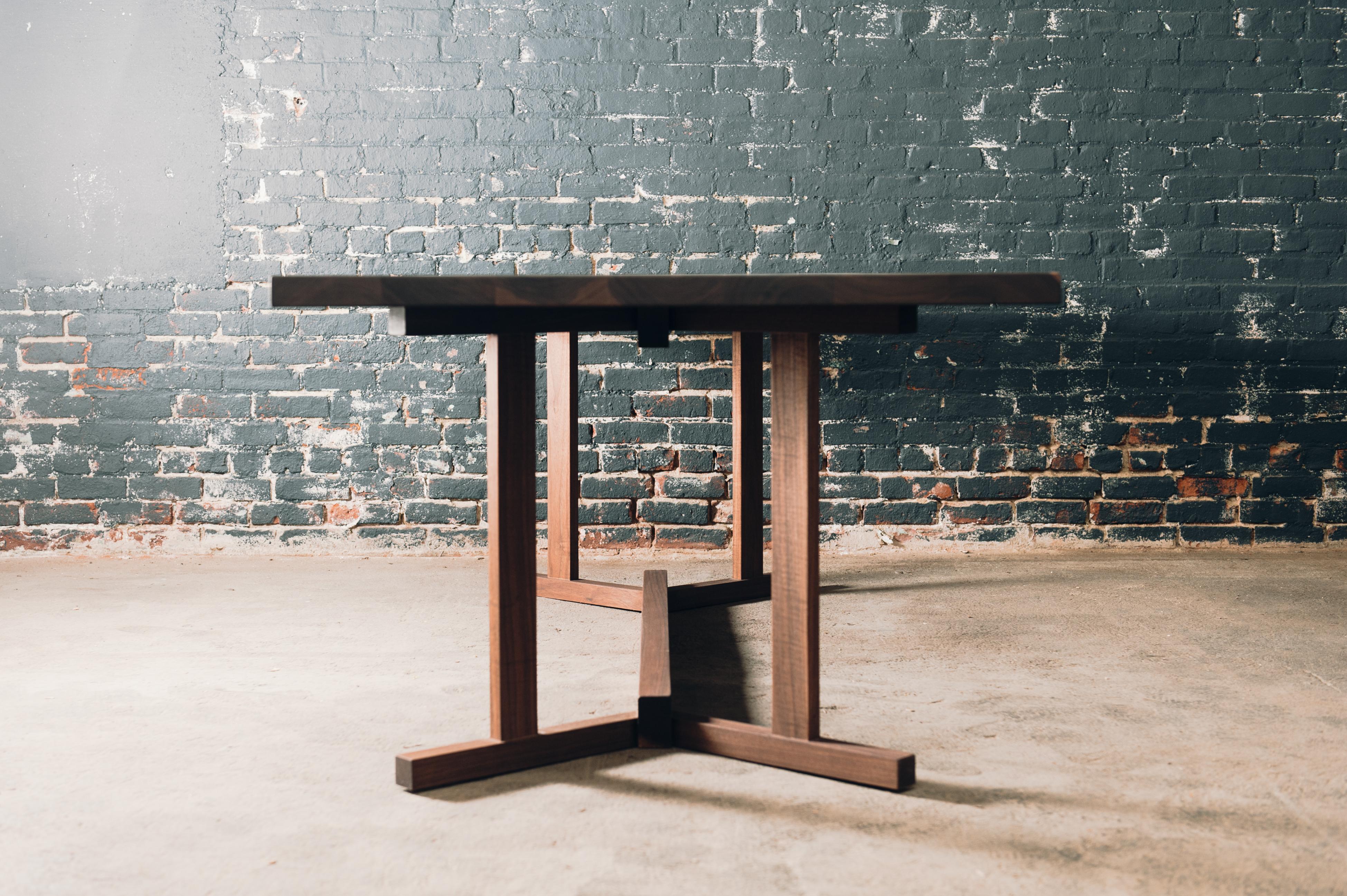 The Liberty is a modern trestle style. Base allows for seating around the entire table without being in the way of chairs and legroom. Made from walnut with a natural finish. This table is made to order please inquire about custom sizes. 