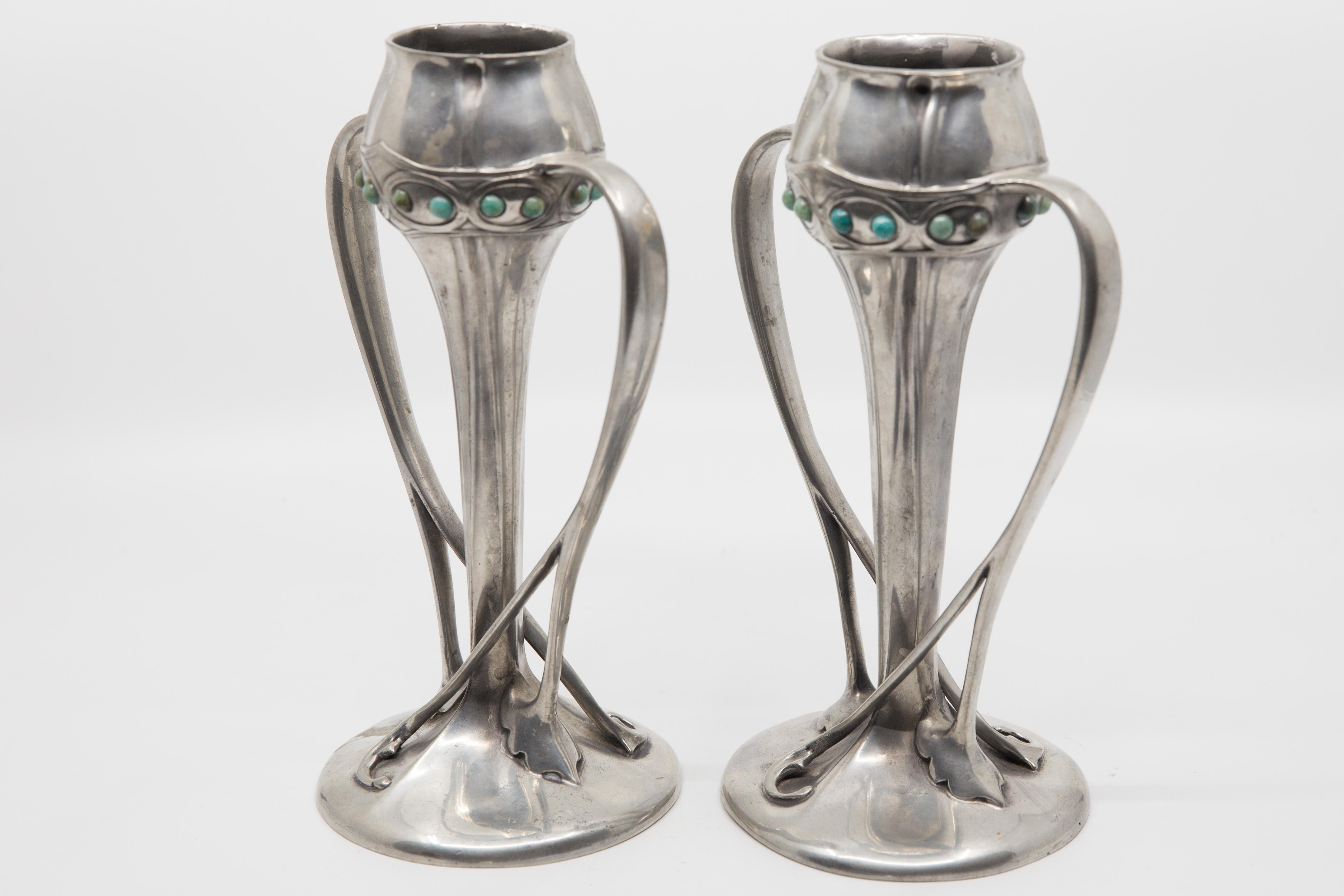Offered is a pair of Tudric Liberty of London, Archibald Knox Art Nouveau pewter vases with turquoise enameled cabochon jewels created circa 1920. Tudric is a brand name for pewterware made by W.H. Haseler's of Birmingham for Liberty & Co of London,