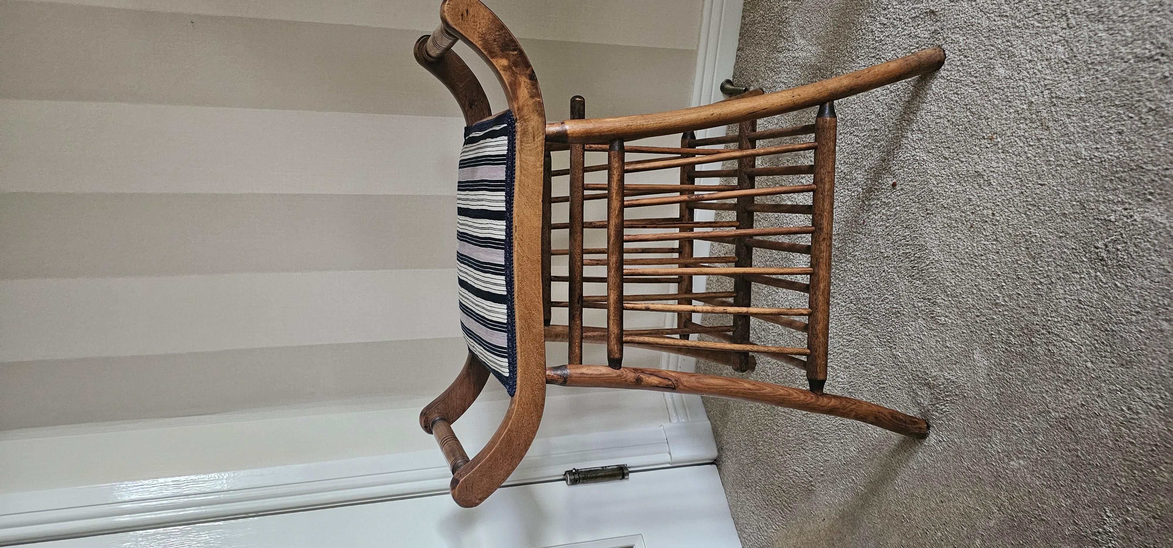 This is a very early 20th century 'Thebes Stool' by Libertys of London. 
In exceptional condition with no cracks or repairs . Probably Bentwood or Pine . The stool seat hss been recovered in 1960's Ewe textile from the Volta region of Ghana . The