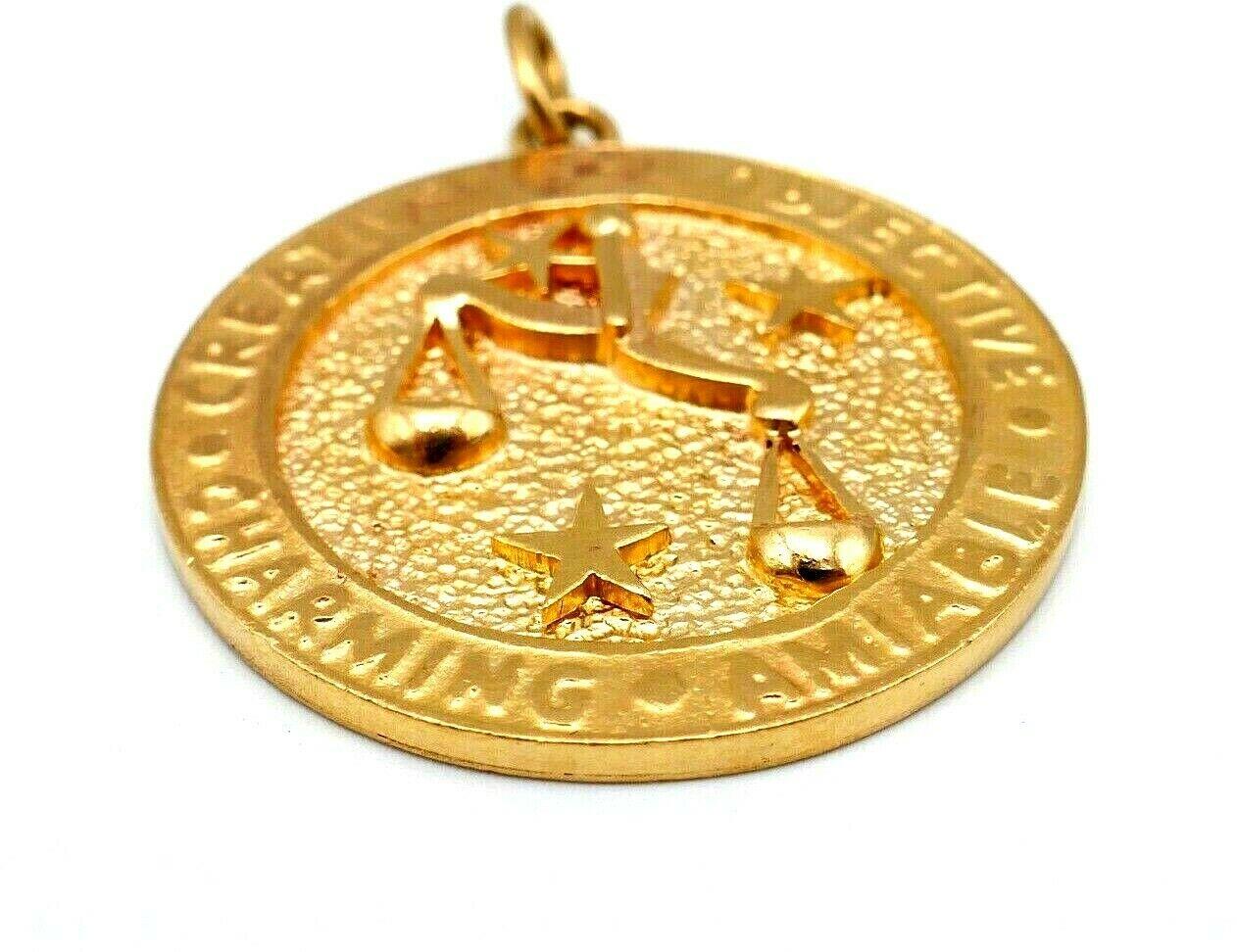 Libra Zodiac sign pendant signed by one of Tiffany & Co. makers. Made of 14k yellow gold, hammered on the front side and polished on the back. The writing on the edge says: 